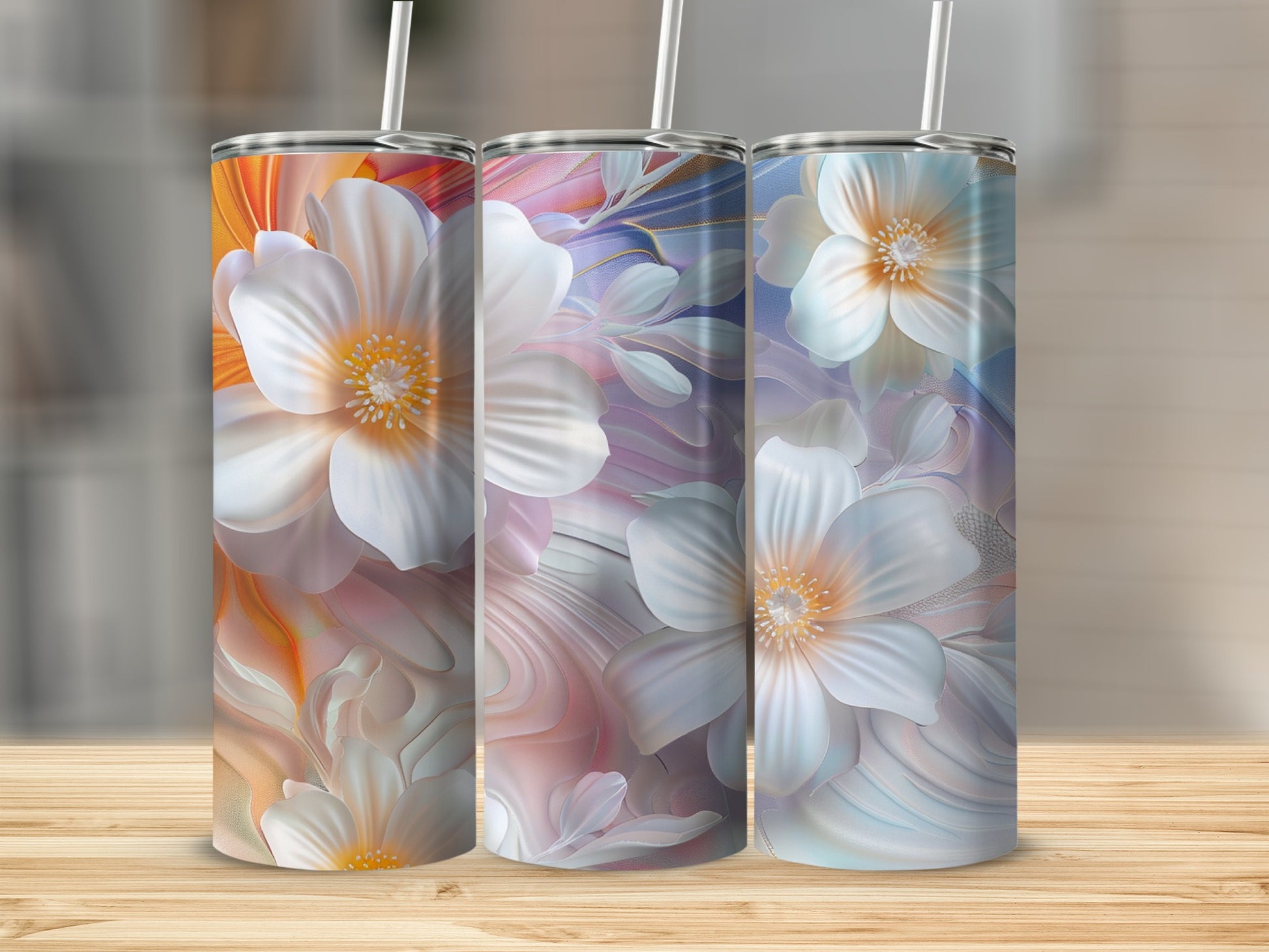 Three tall tumblers with colorful floral patterns and white straws.