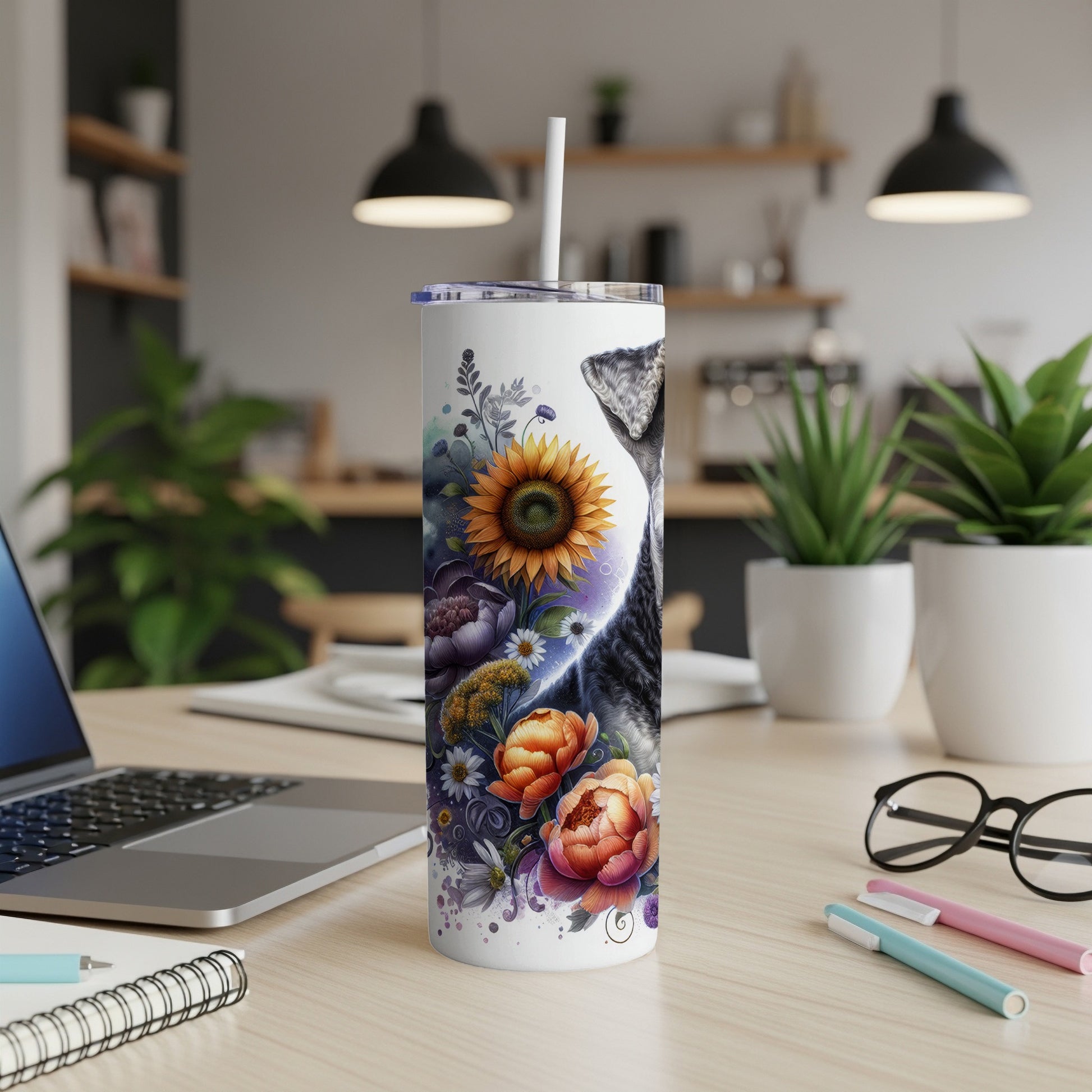 White tumbler with a cat and floral design on a desk.