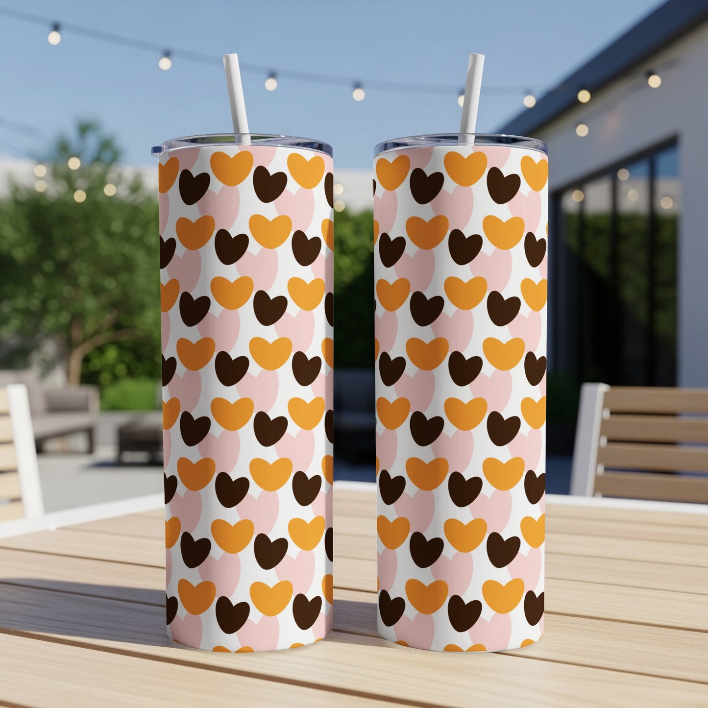 Two tumblers decorated with a repeating pattern of pink, orange, and brown hearts.