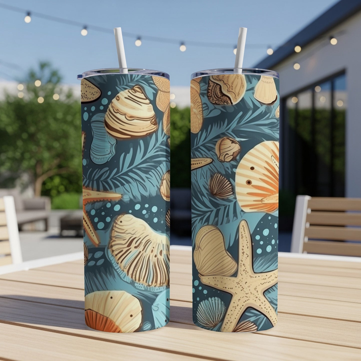 Two tumblers with seashells and palm fronds pattern on a table.