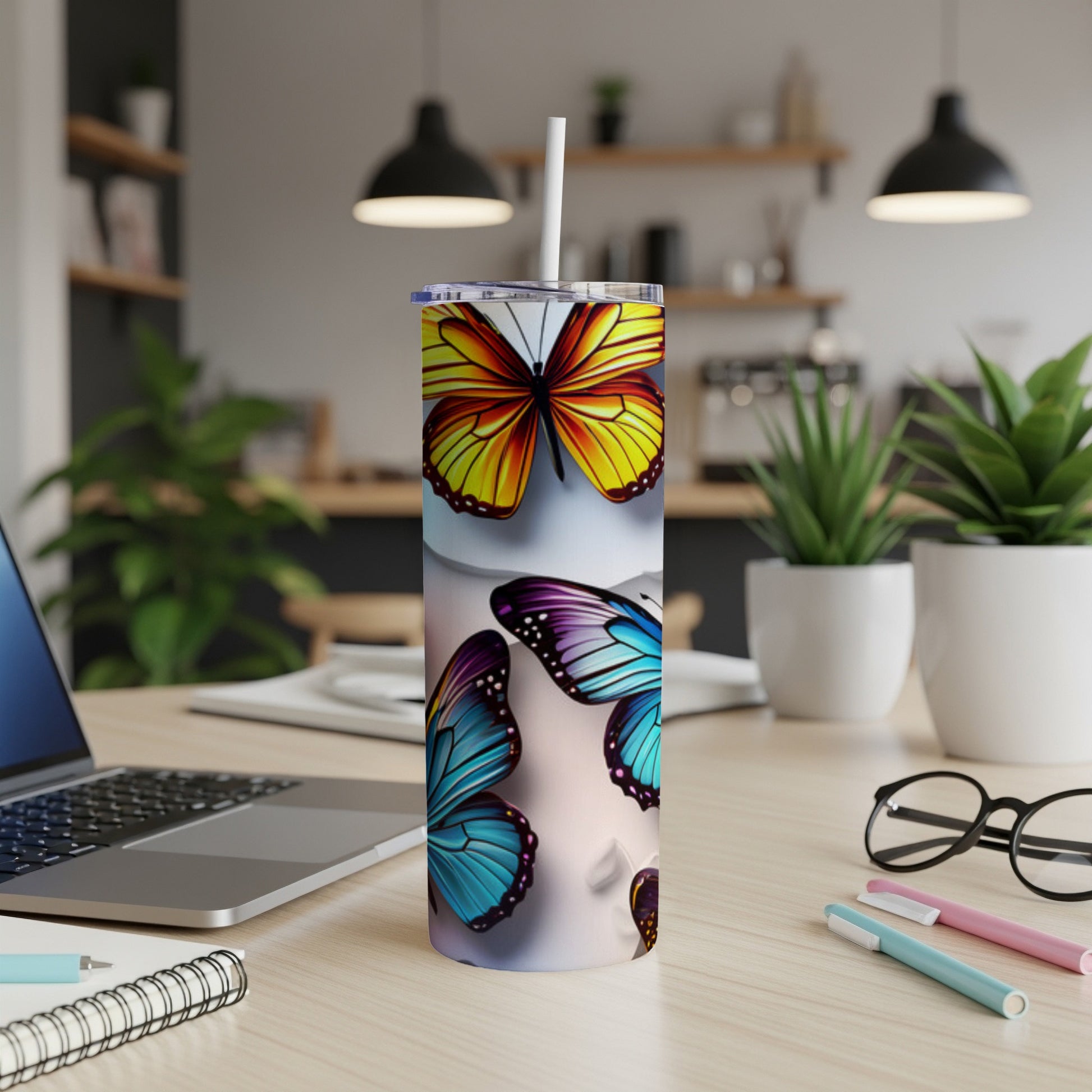 Tall tumbler with colorful butterfly designs on a desk.