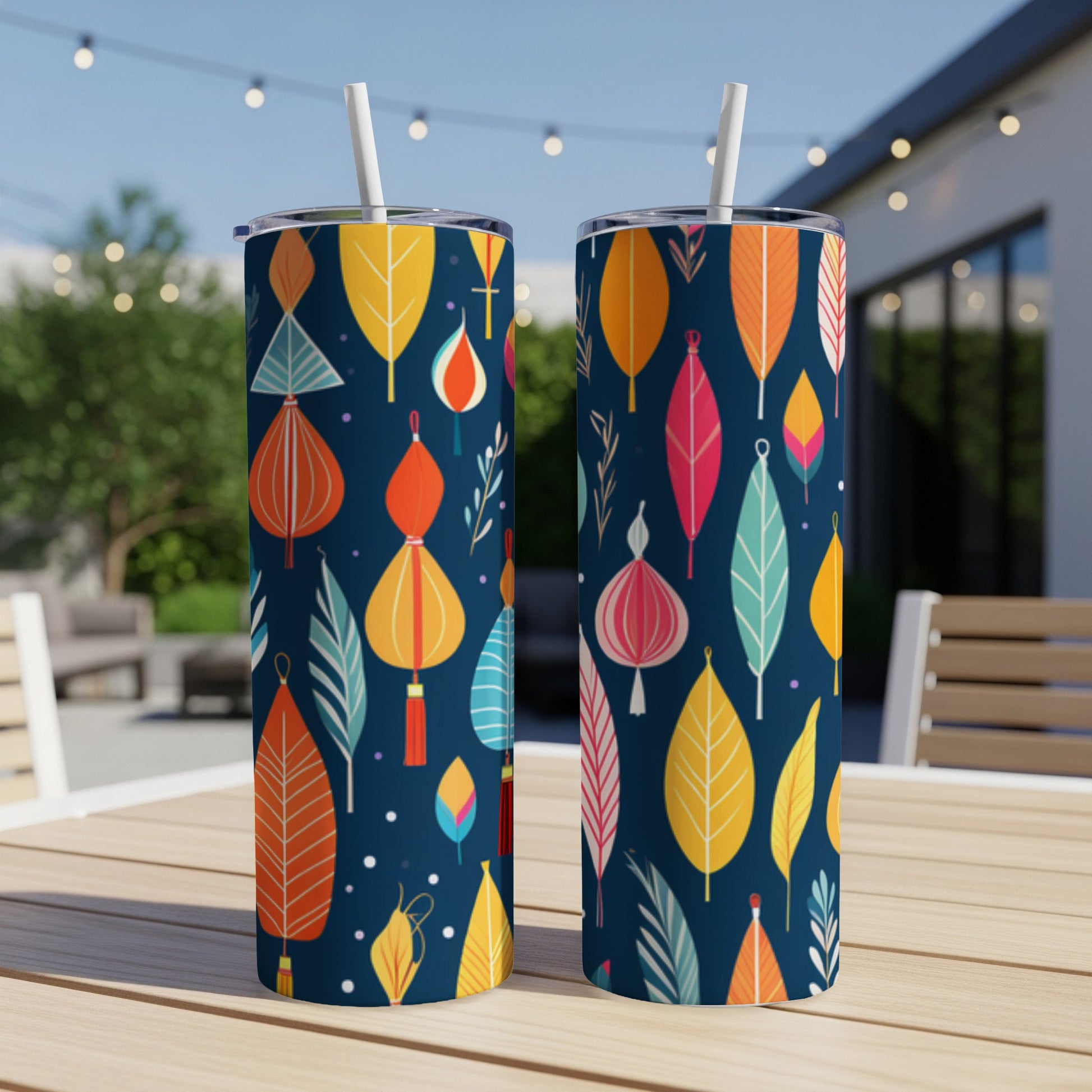 Two tall, dark blue tumblers with colorful abstract leaf and lantern patterns.