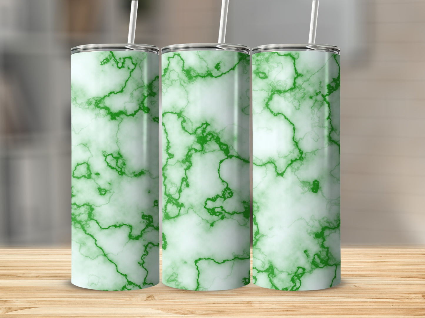Three green marble patterned tumblers with white straws on a wooden surface.