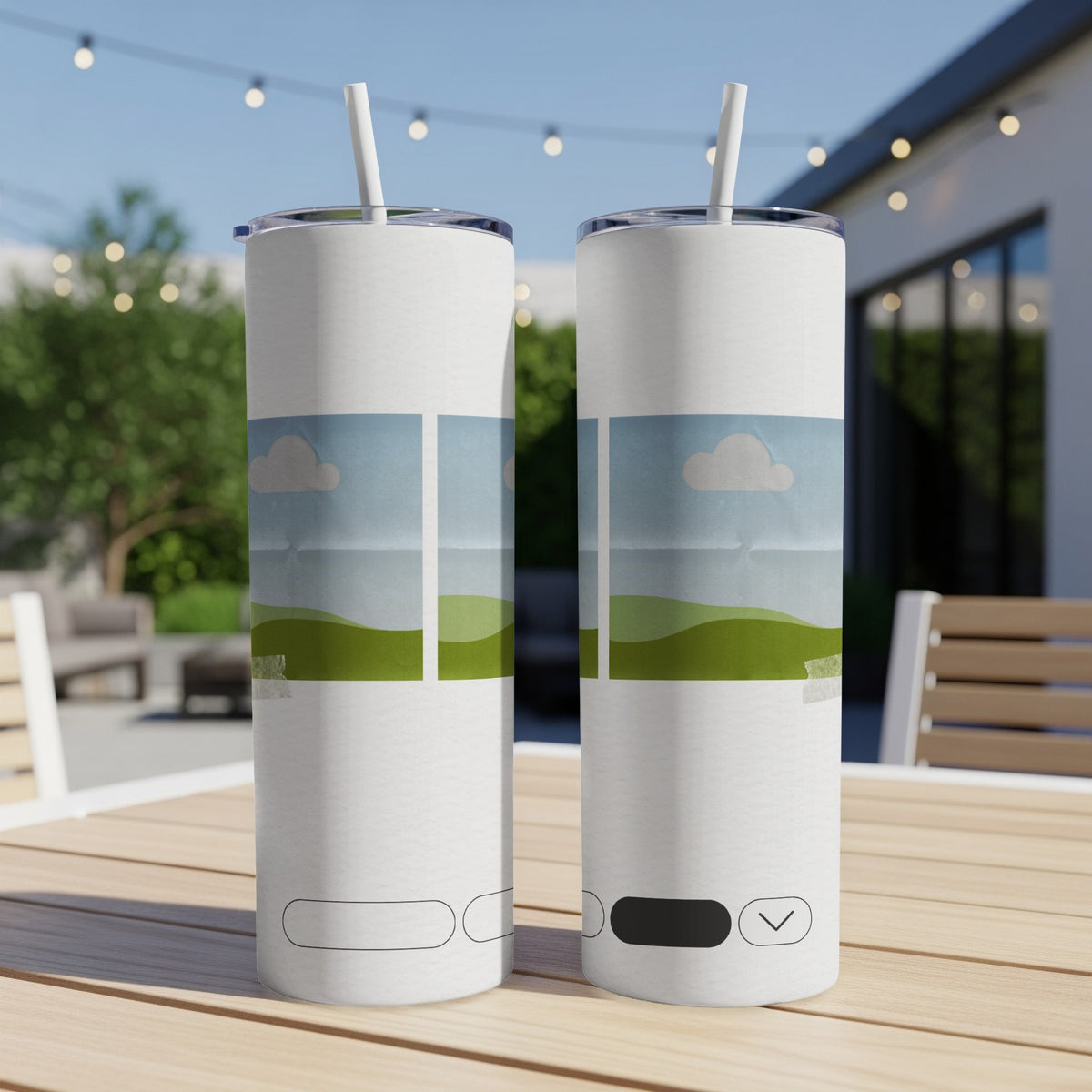 Two white tumblers with a landscape design sit on a wooden table outdoors.