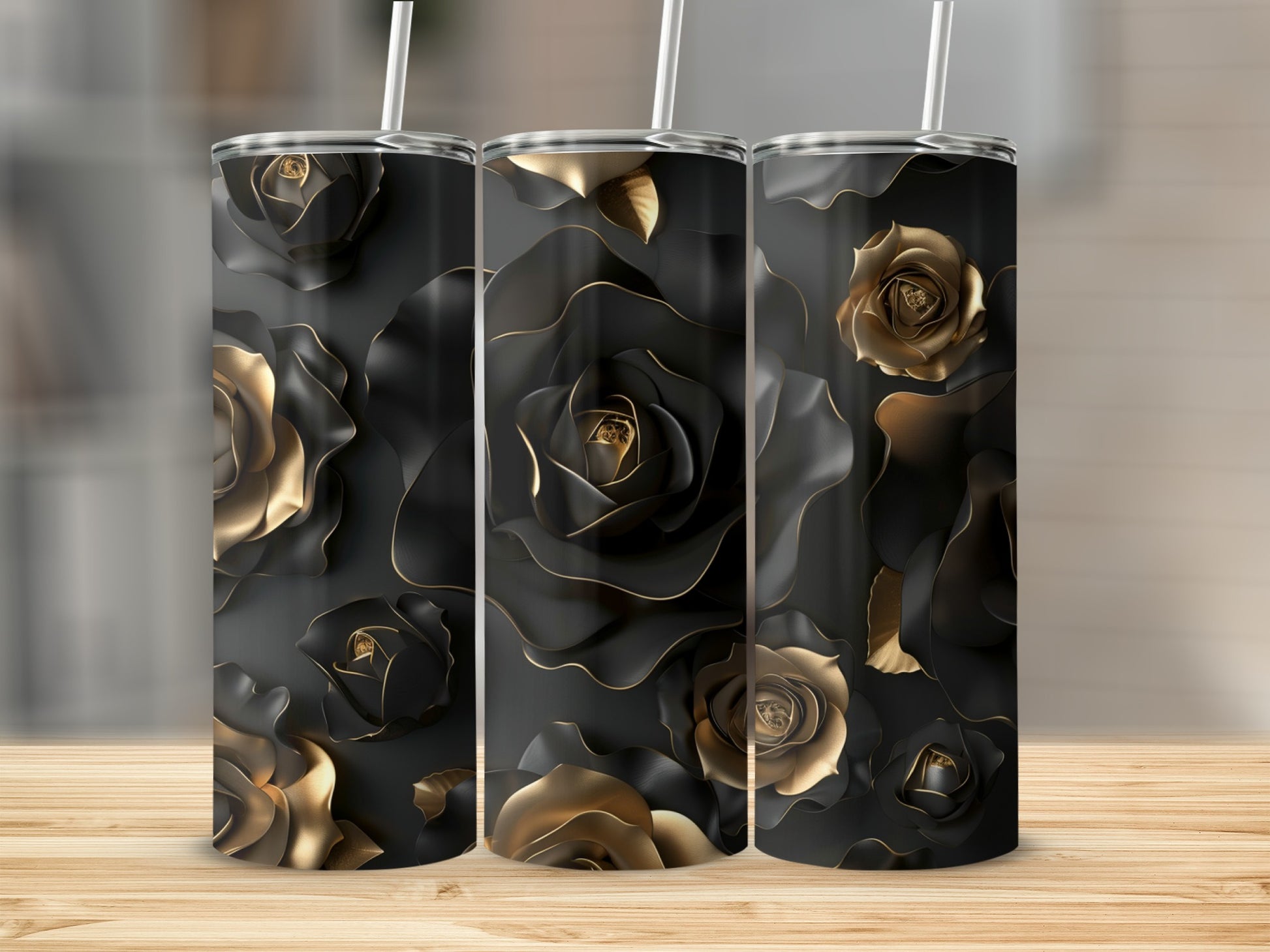 Three tumblers with black and gold rose pattern on a wooden surface.