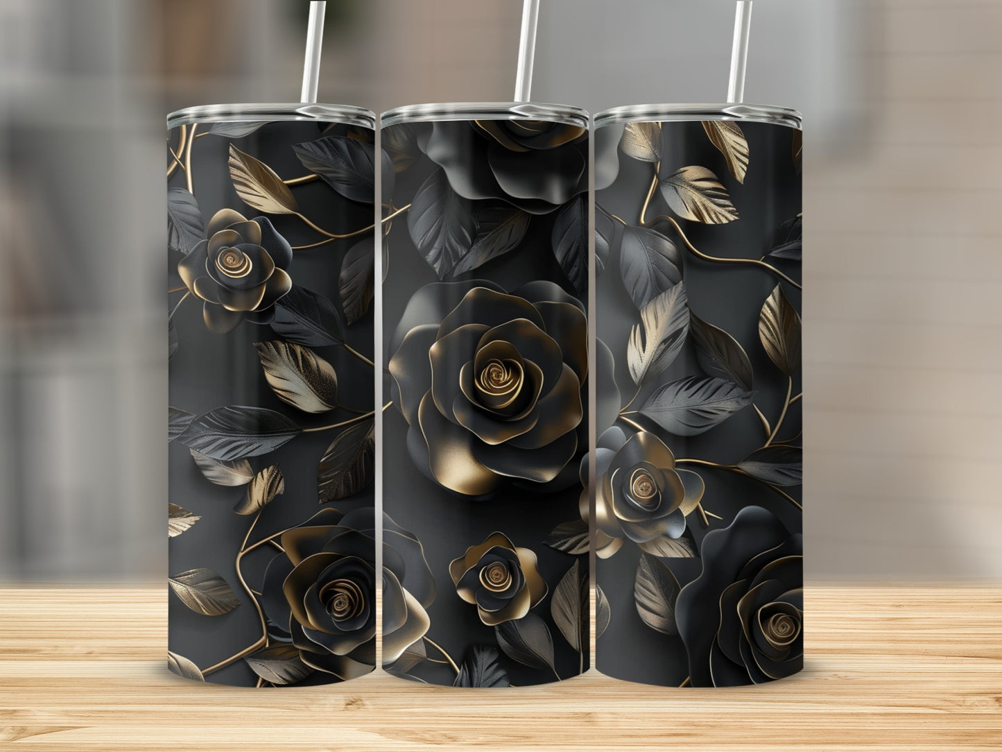 Three tumblers with black and gold rose floral design on a wooden surface.