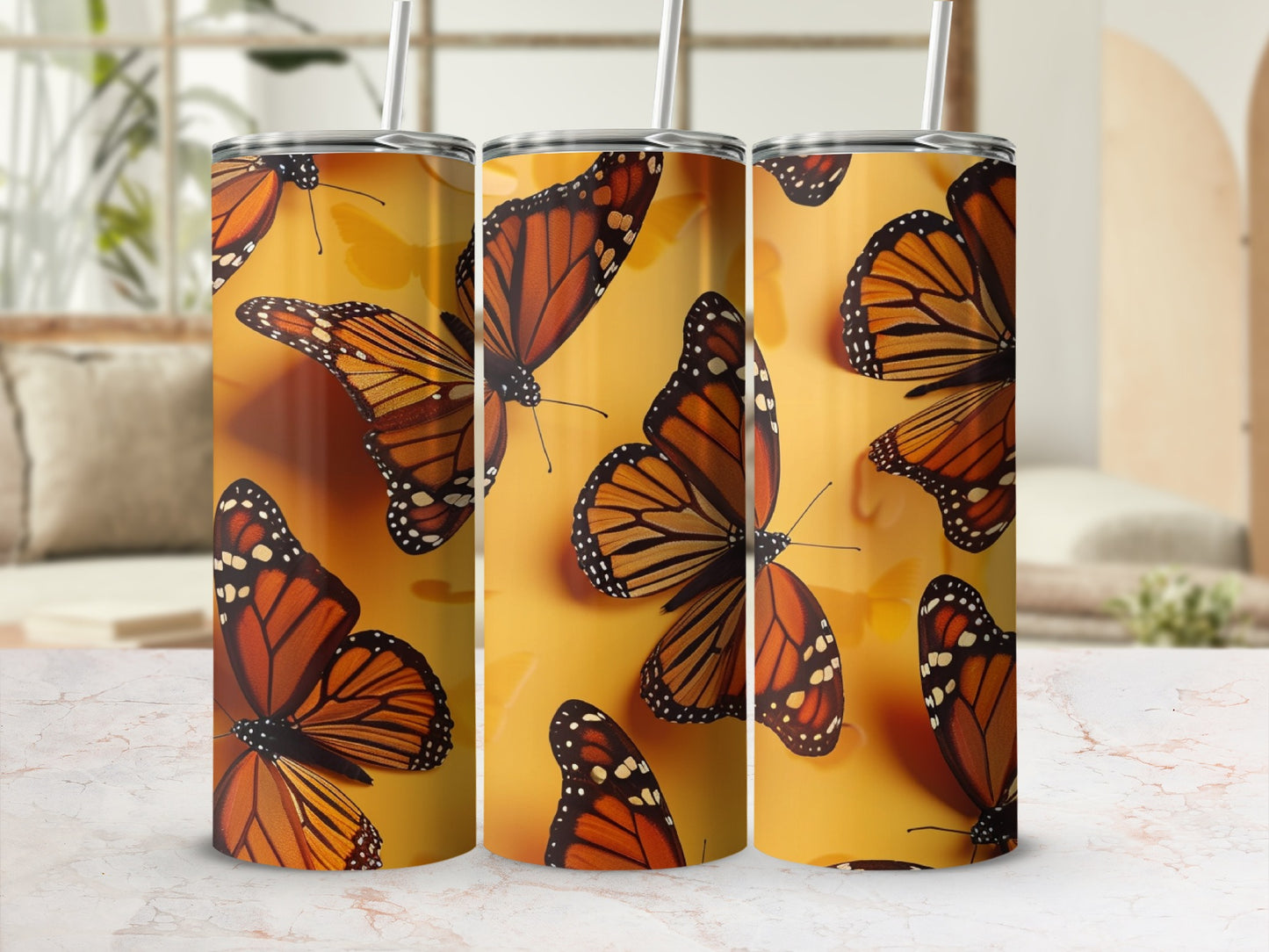 Three tumblers with monarch butterfly pattern on a yellow background.