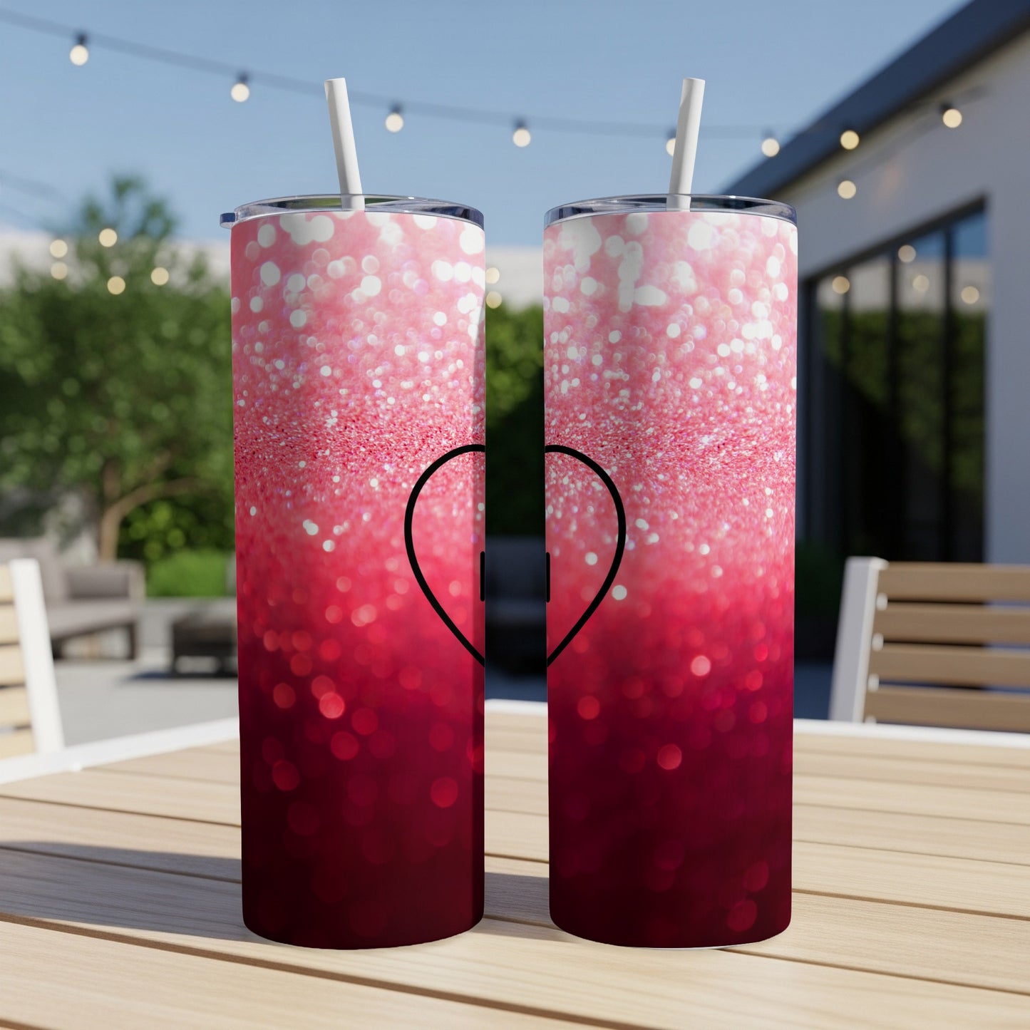 Two tumblers with a pink and red glitter ombre design and a black heart.
