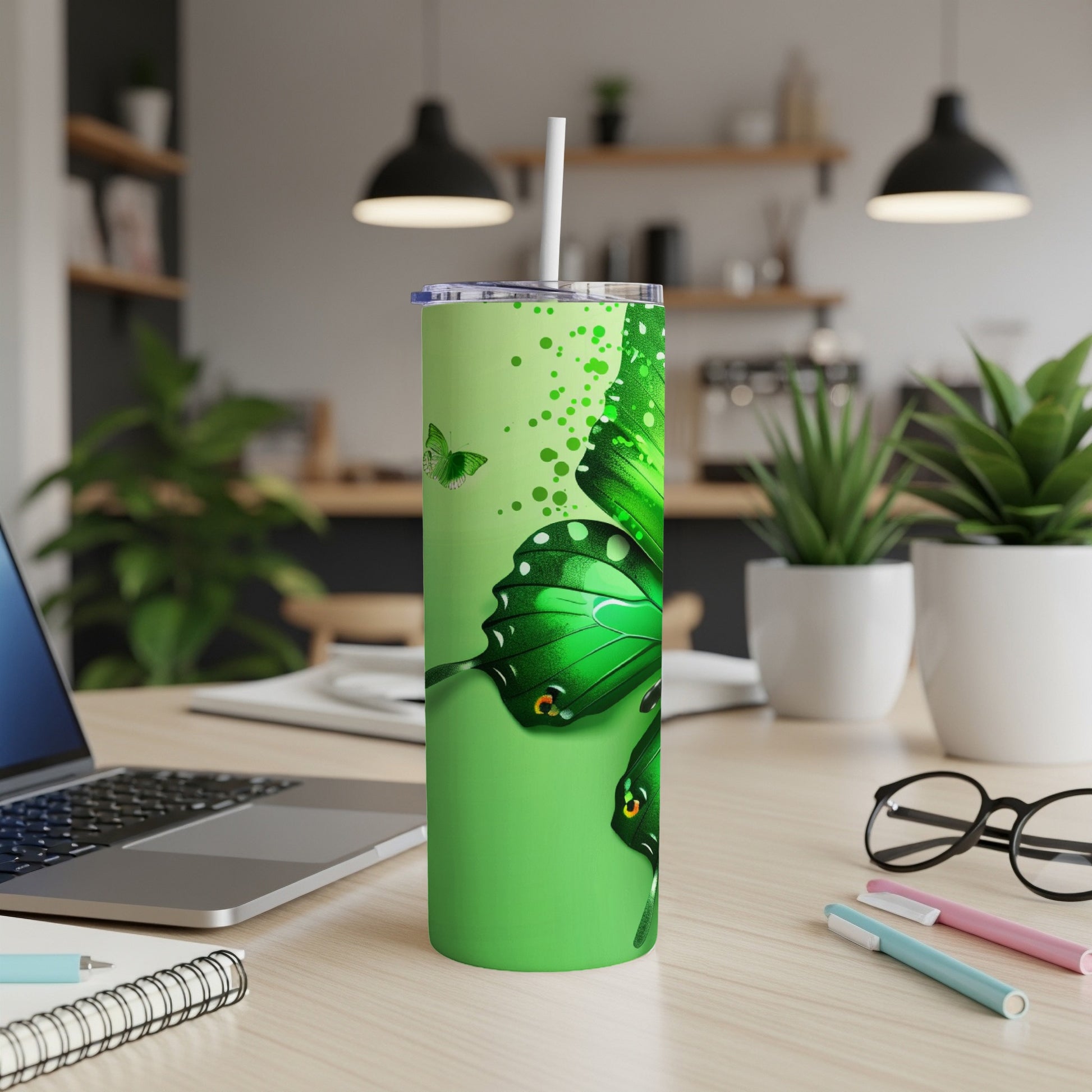 Green tumbler with a large butterfly design and a straw.