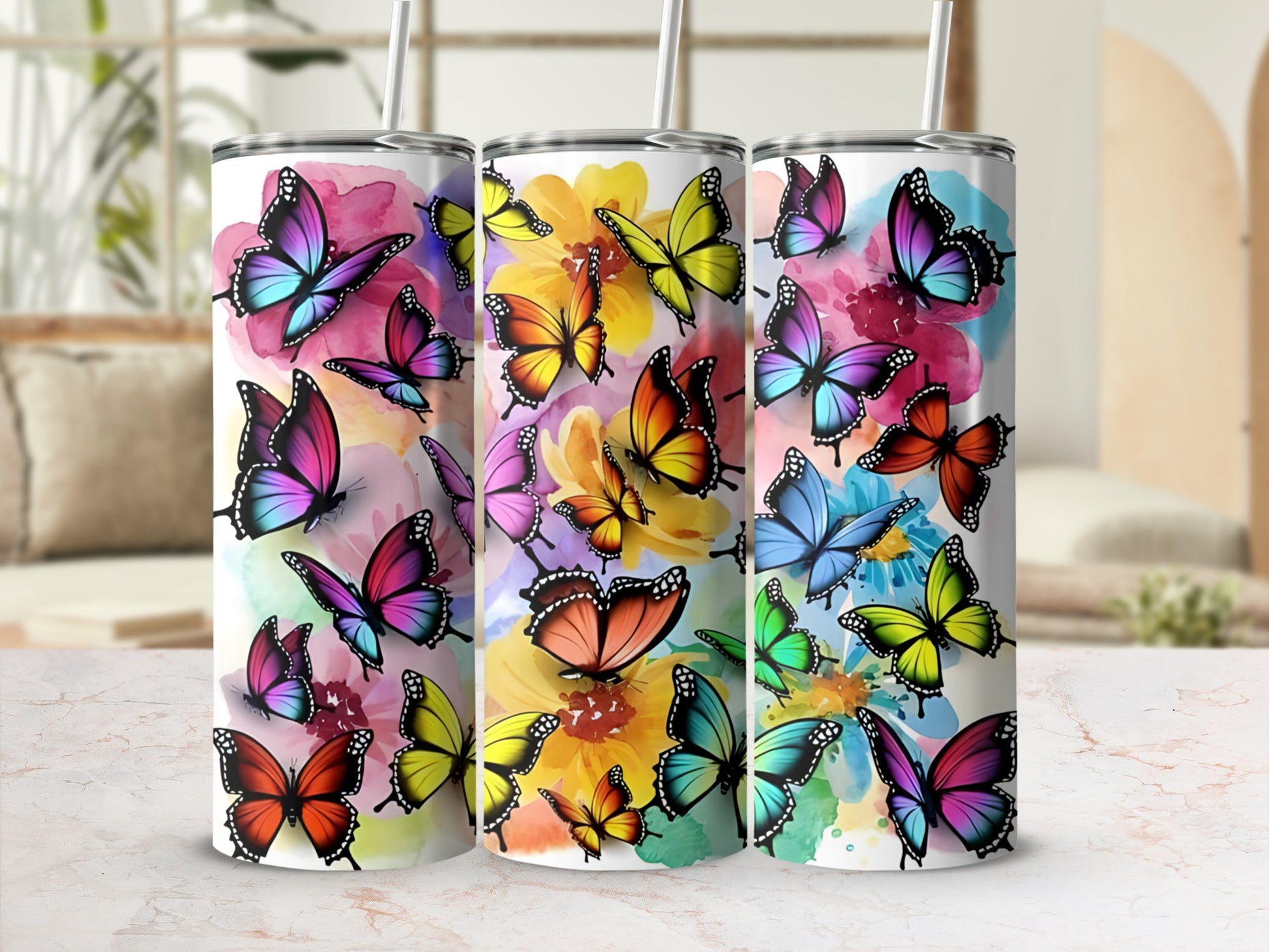 Three tumblers decorated with colorful watercolor butterflies.