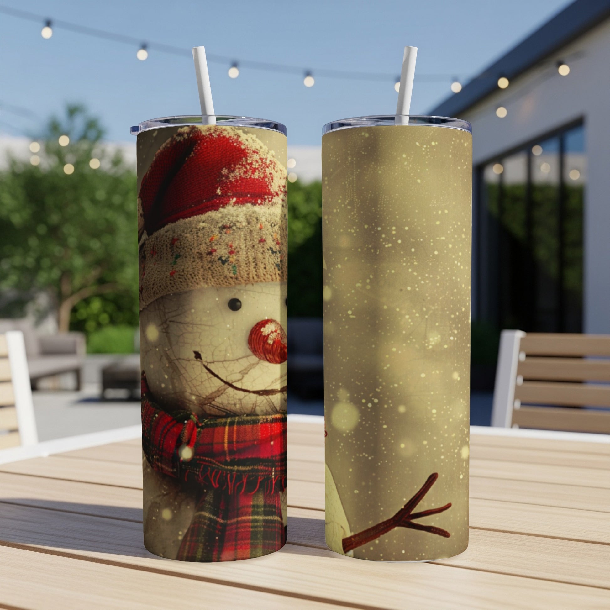 Two tumblers with snowman design and red scarf, on a table.