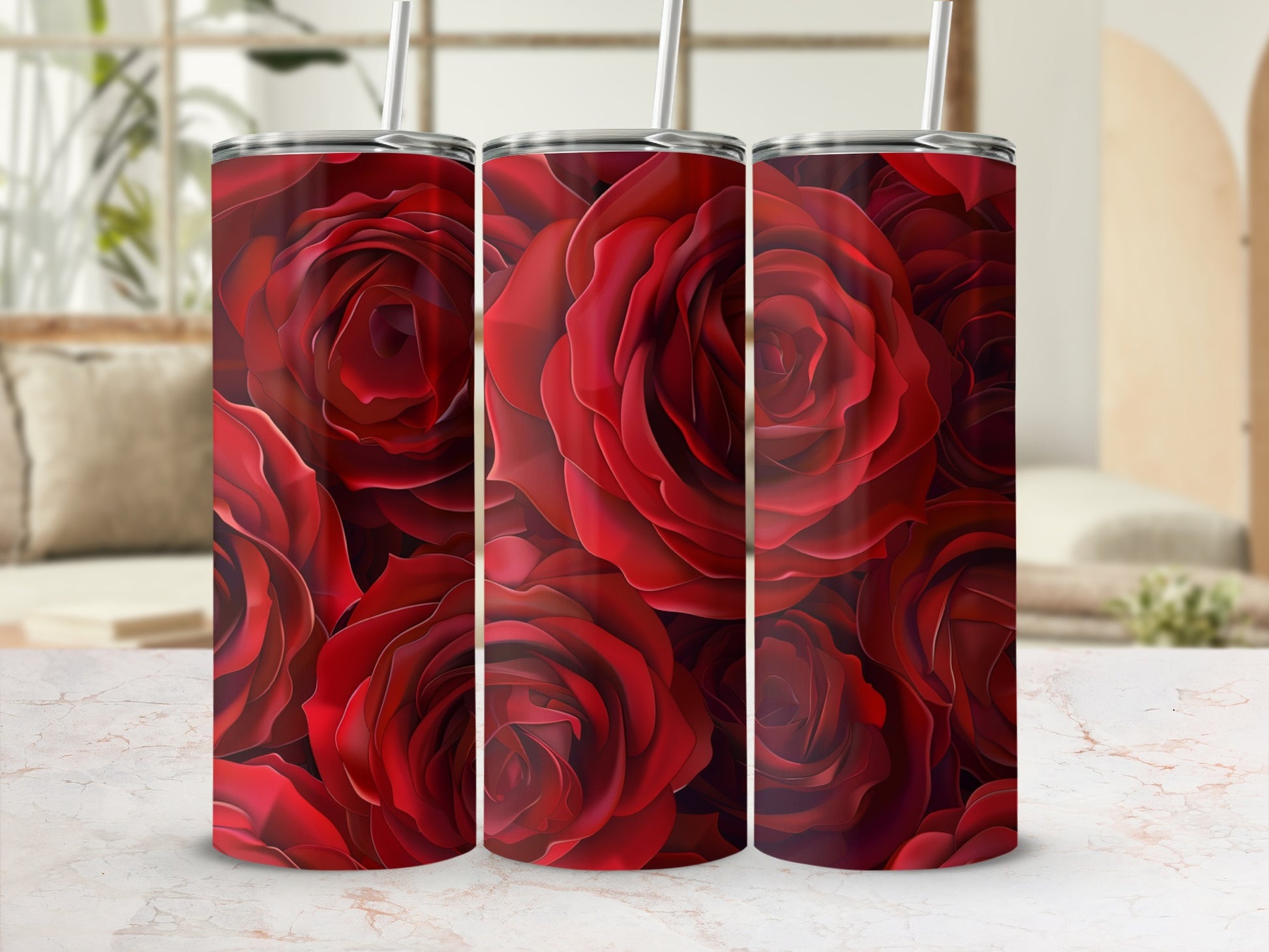 Three red rose pattern tumblers with straws on a marble countertop.
