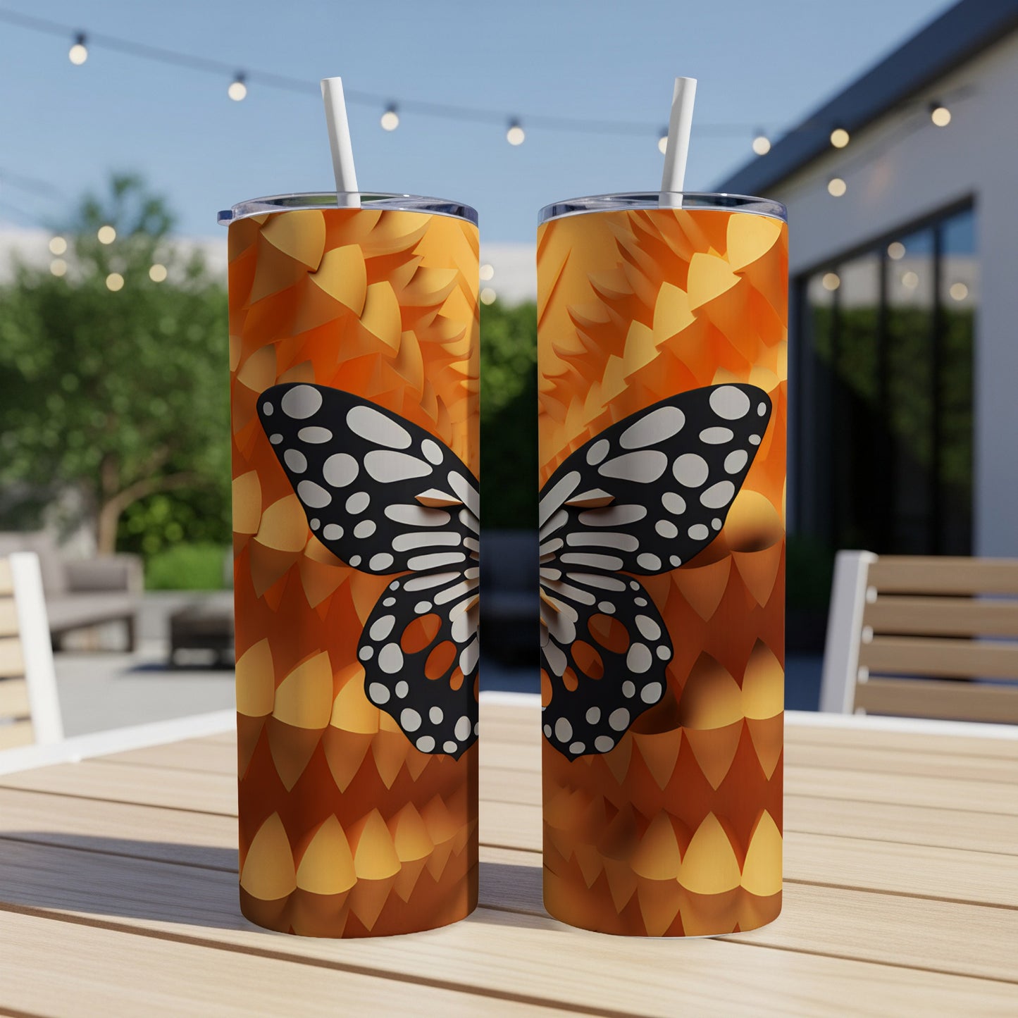 Two tumblers with a butterfly design and scales pattern on a patio table.