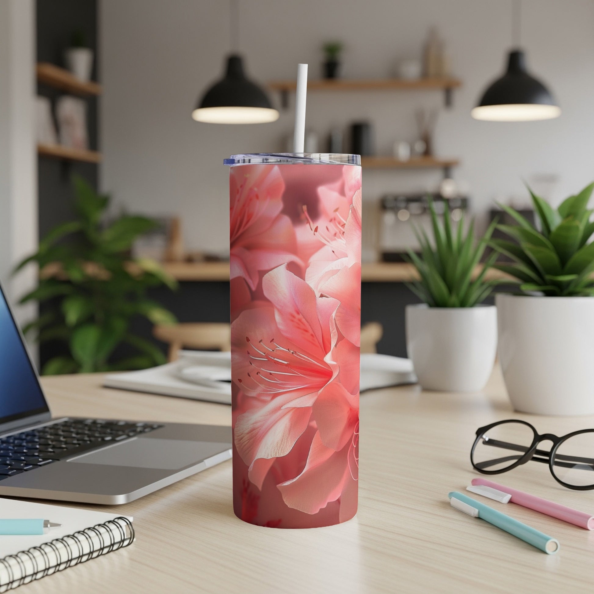 Coral pink azalea flowers on a stainless steel tumbler.