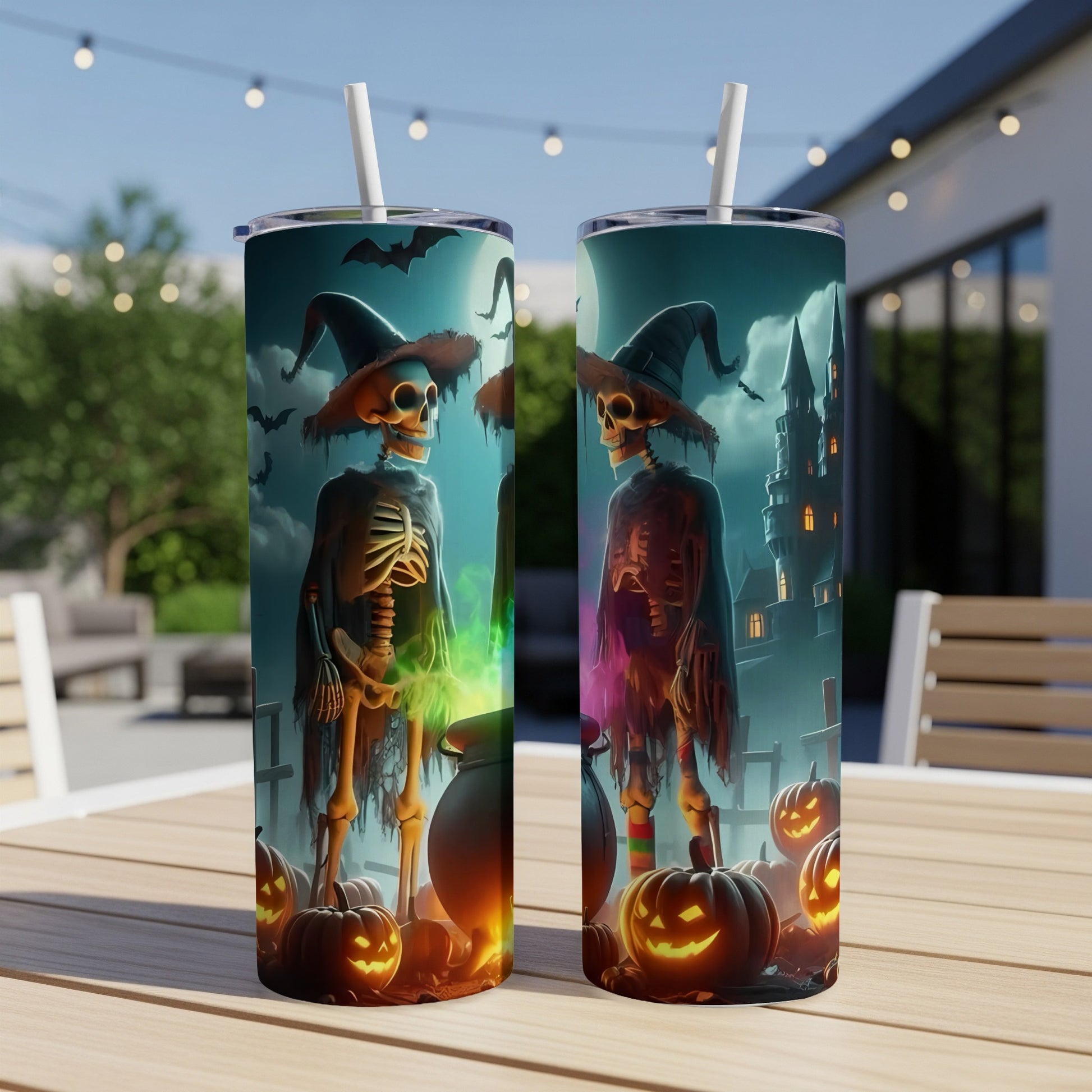 Two Halloween themed tumblers with skeletons, jack-o-lanterns, and a castle on a table.