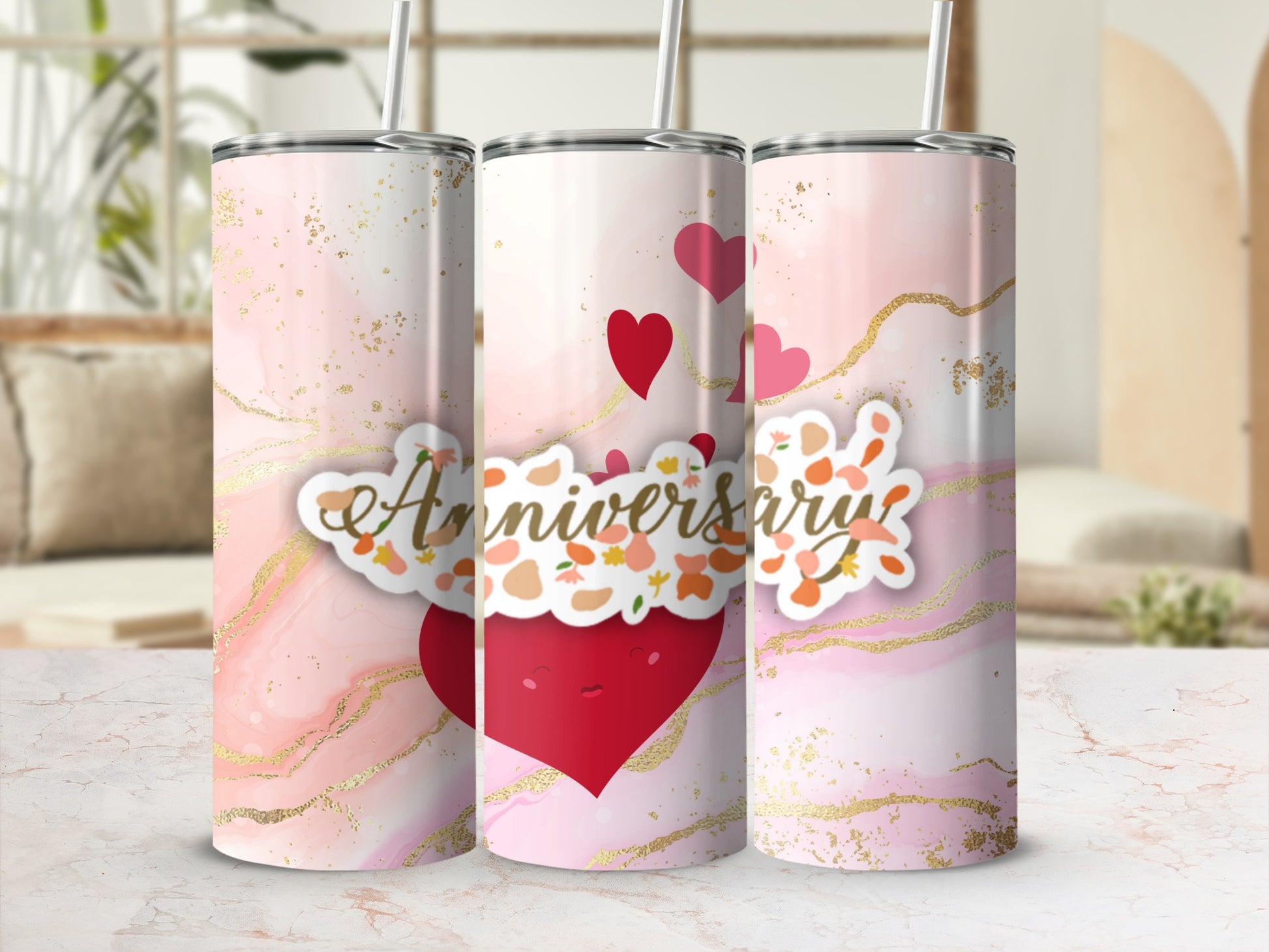 Anniversary tumbler with hearts and swirling gold accents on a pink marbled background.