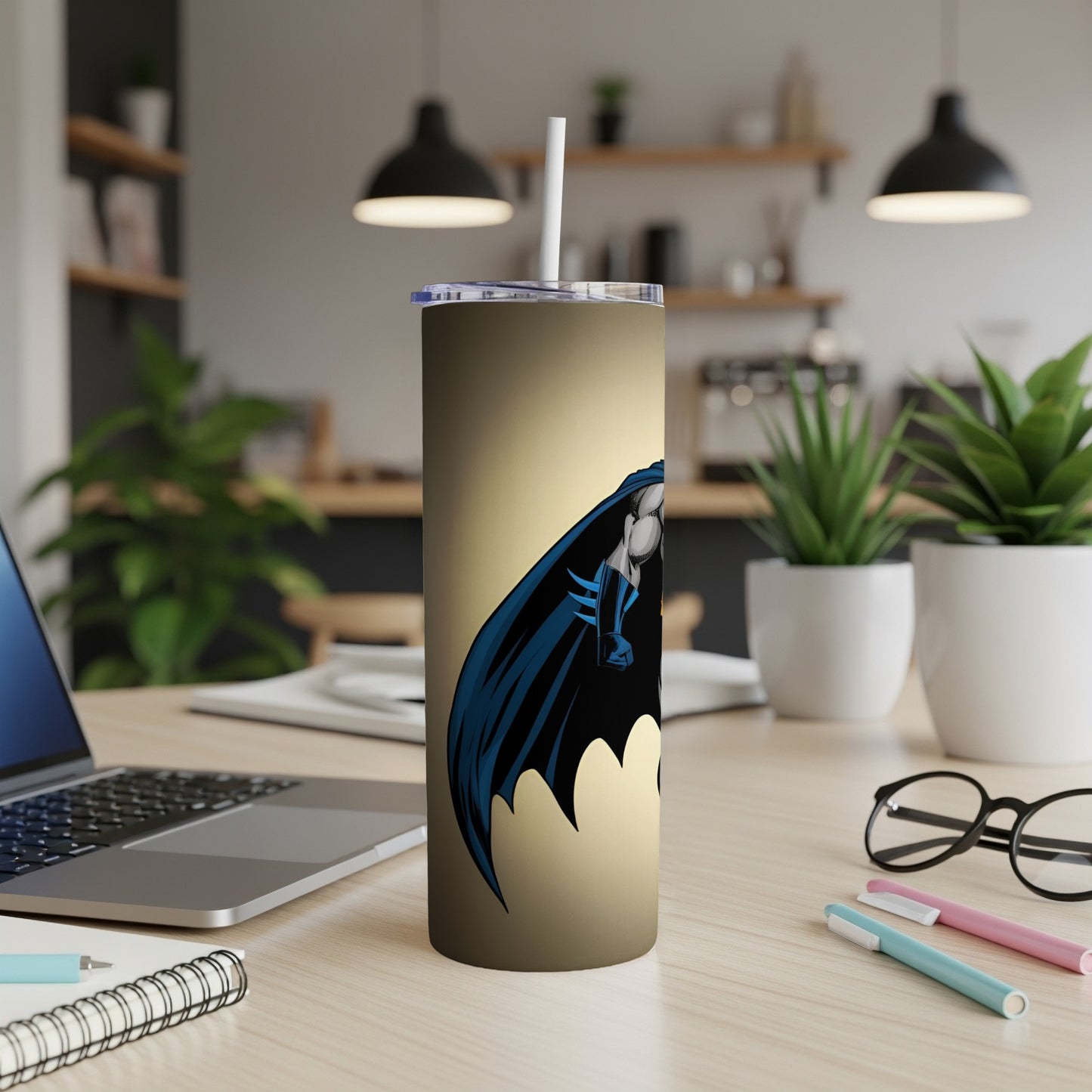 Tall tumbler with Batman graphic and straw on a desk.