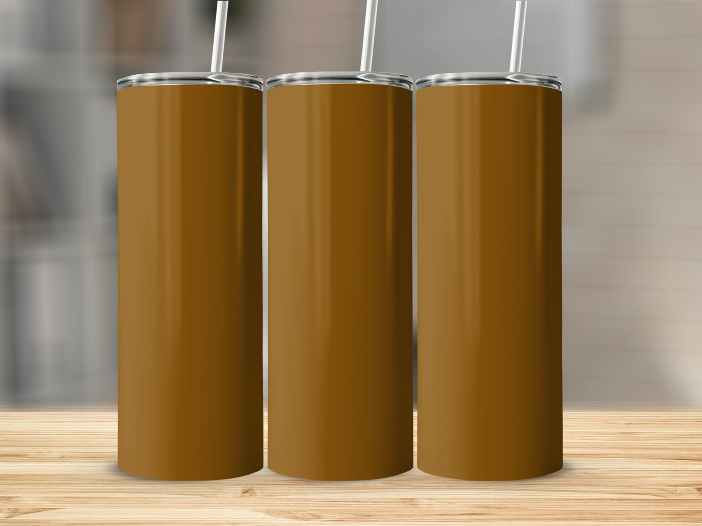 Three tall, brown tumblers with white straws stand on a wooden surface.