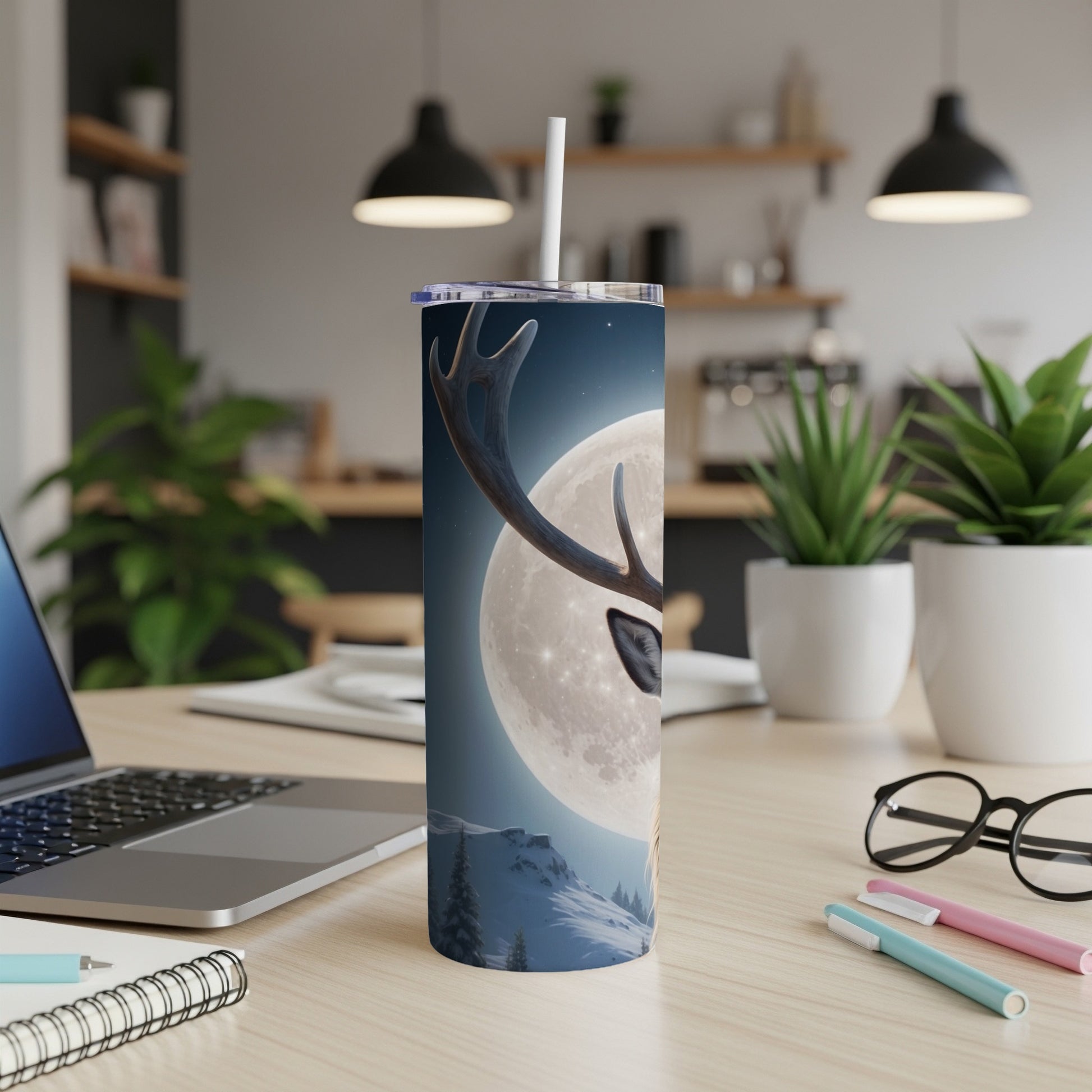 Reindeer and moon design on a white tumbler with a straw.