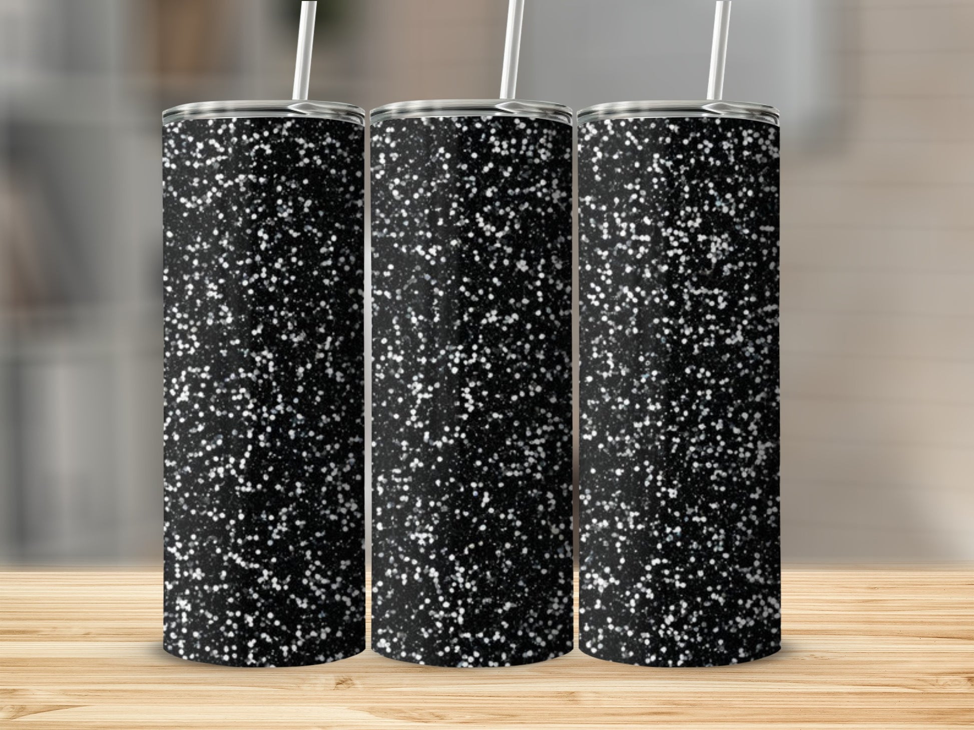 Three tumblers with a black glitter design and white straws.