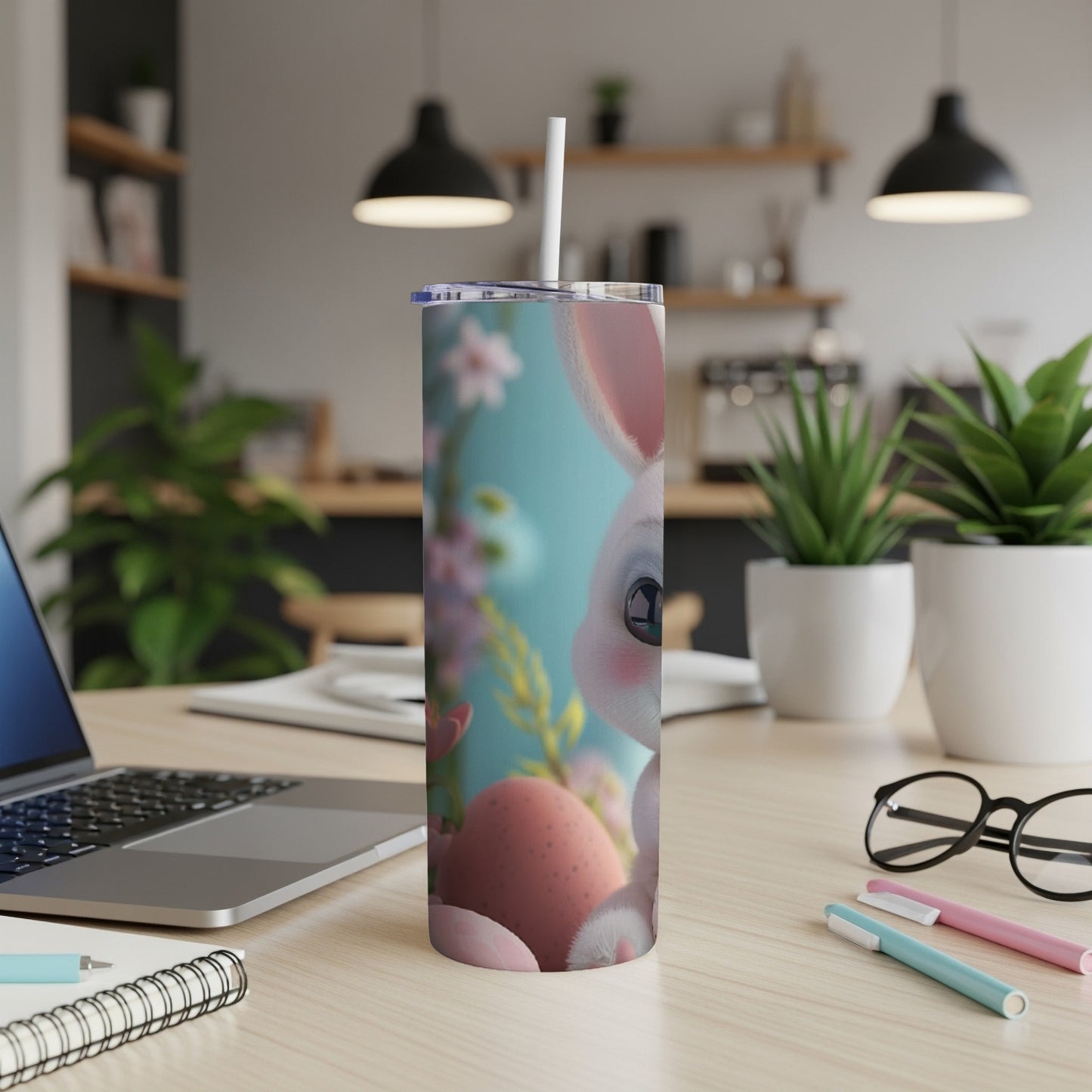 Easter bunny tumbler with pink eggs and flowers on a desk.