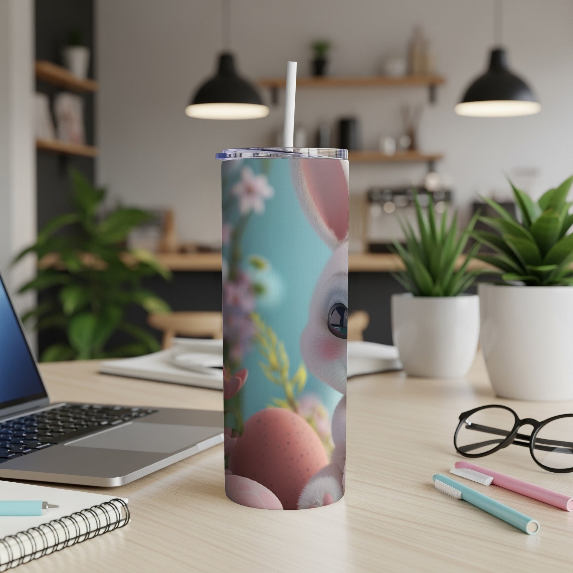 Easter bunny tumbler with pink eggs and flowers on a desk.