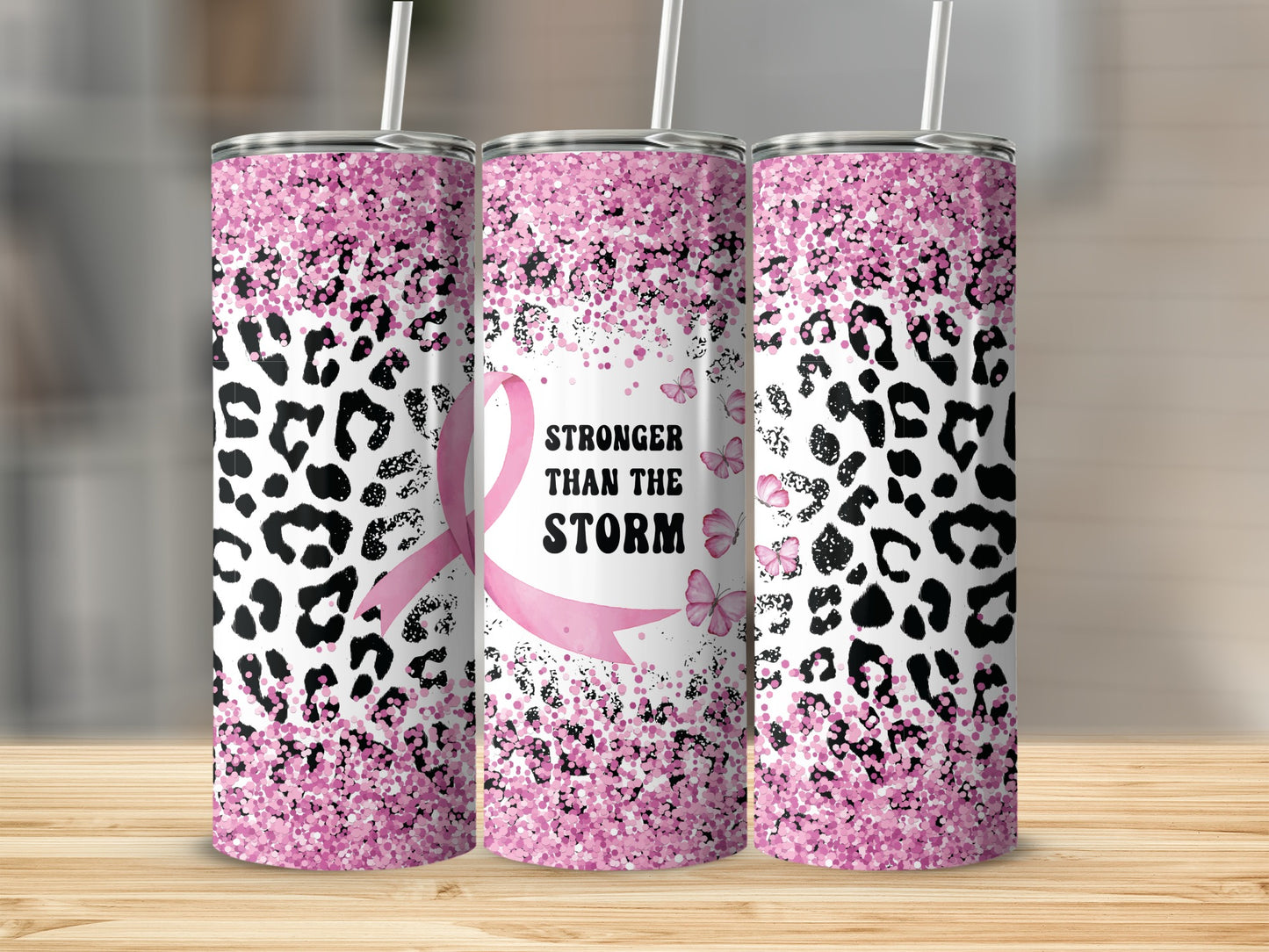 Pink glitter leopard print tumbler with "Stronger Than The Storm" text and ribbon.
