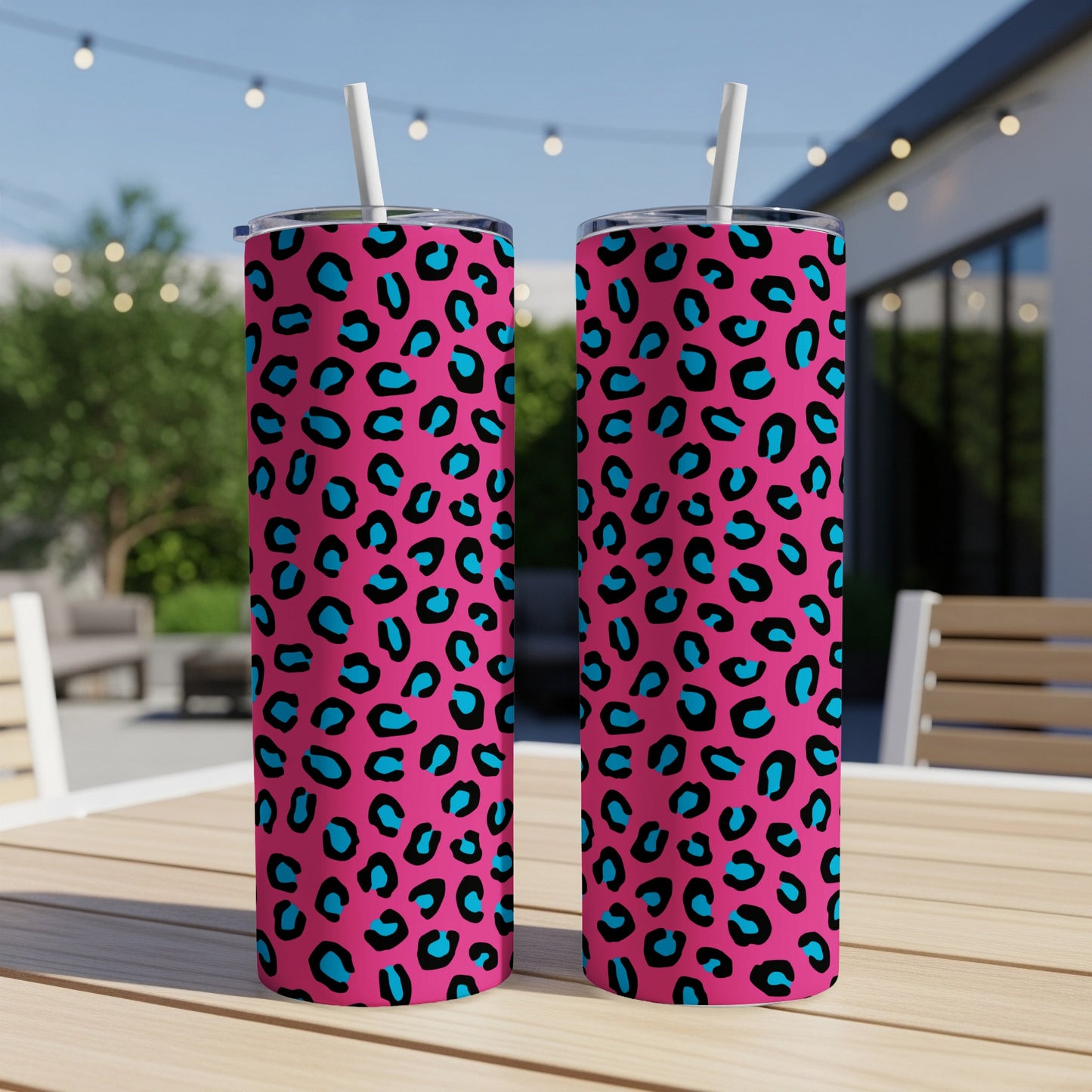 Two pink tumblers with blue and black leopard print, each with a white straw.