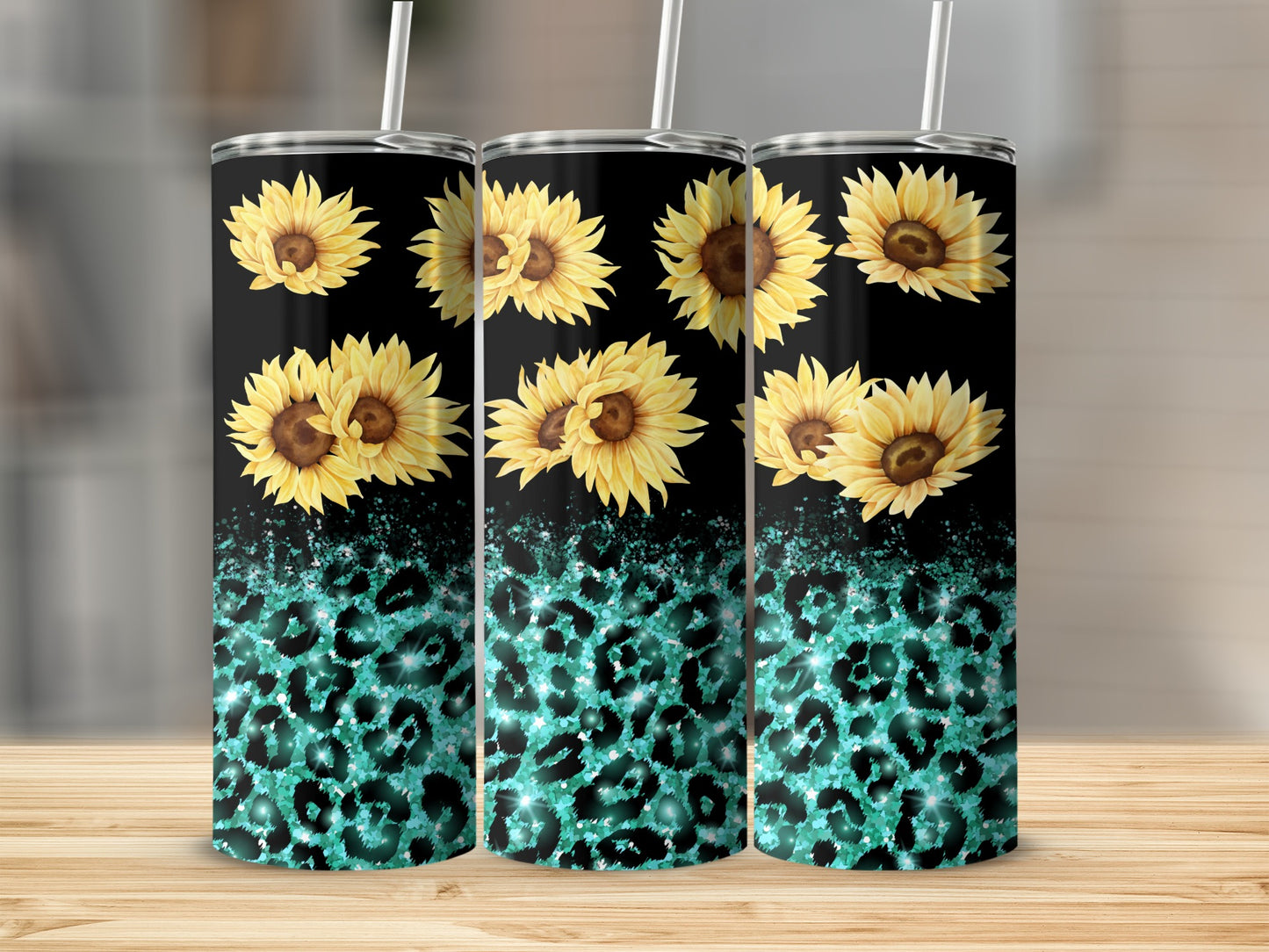 Three tumblers with sunflowers and teal leopard print on a wooden surface.