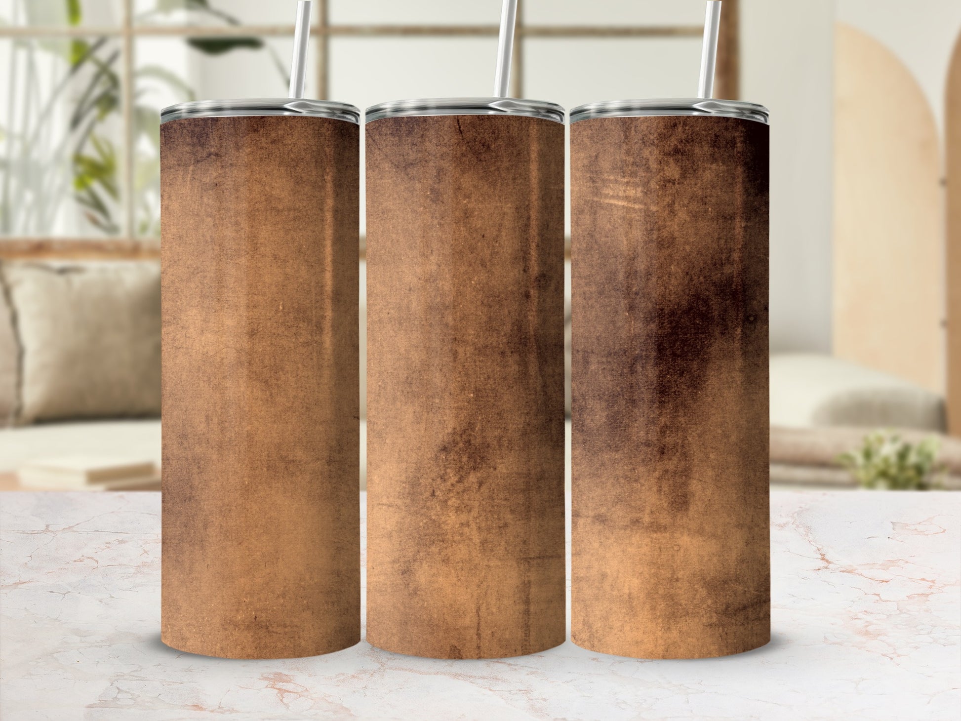 Three tumblers with a textured brown design stand on a marble surface.
