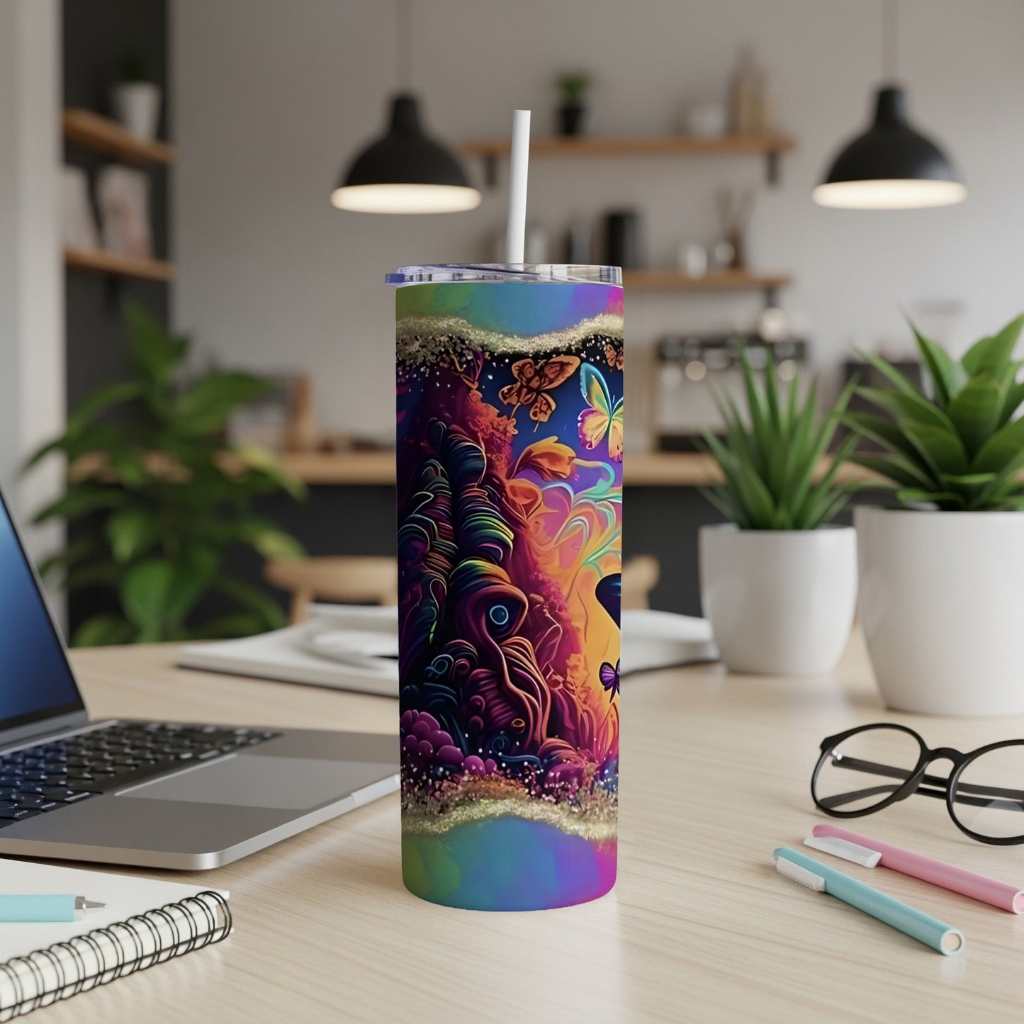 Tall tumbler with psychedelic jungle and butterfly design on a desk.