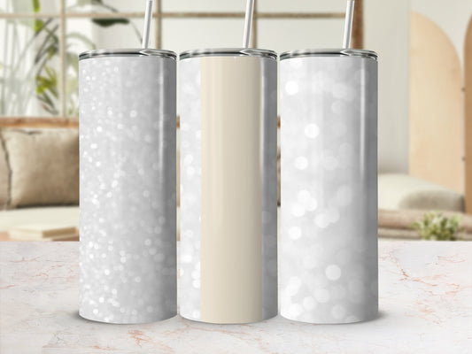 Three glitter tumblers with straw on marbled surface.