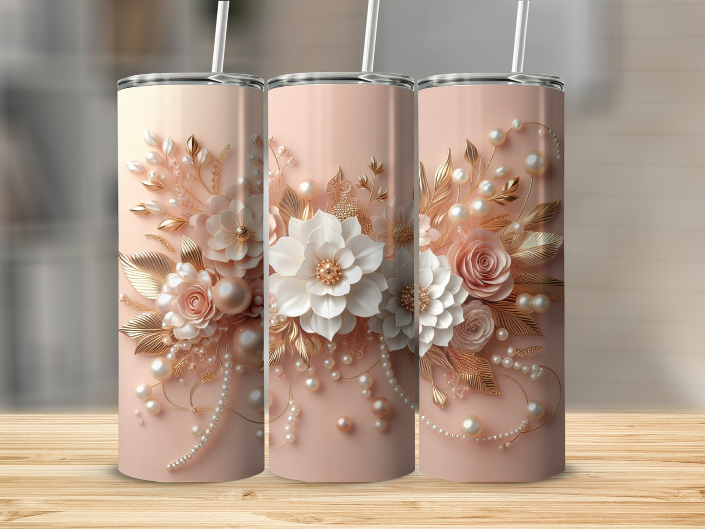 Three rose gold tumblers with floral and pearl embellishments on a wooden surface.