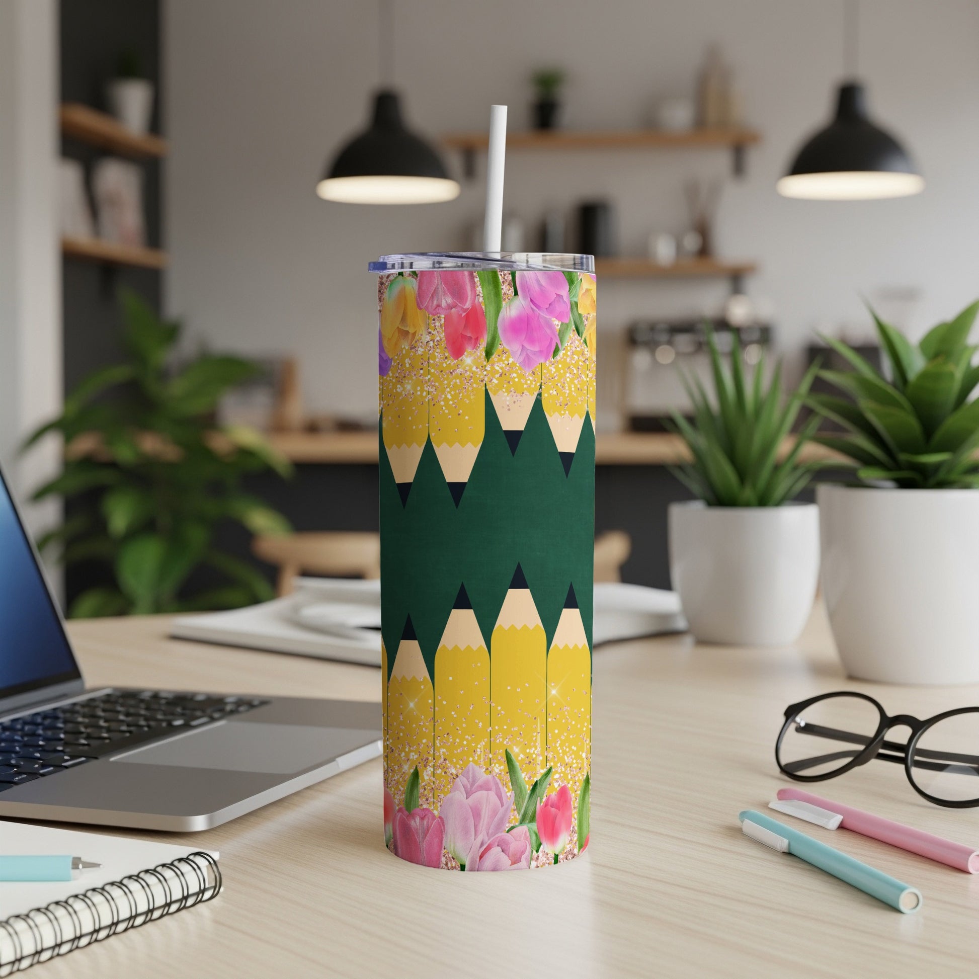 Green tumbler with a pattern of yellow pencils and pink flowers.