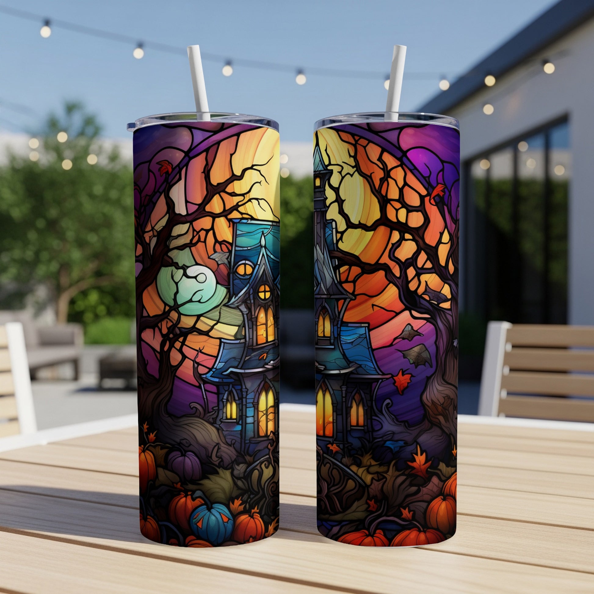 Halloween haunted house stained glass design on two tumblers with straws.