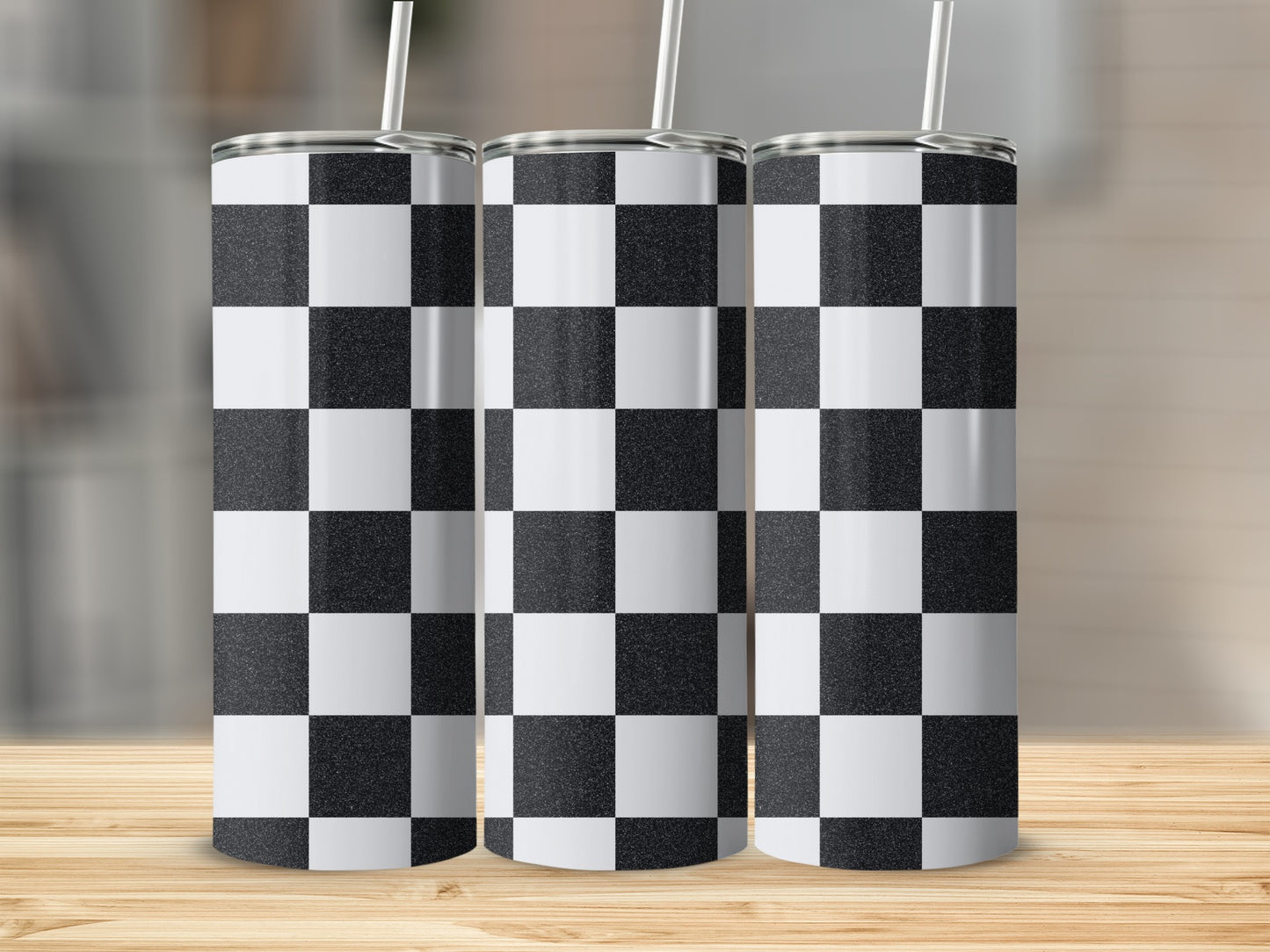 Three tall tumblers with black and white checkerboard pattern and straws.