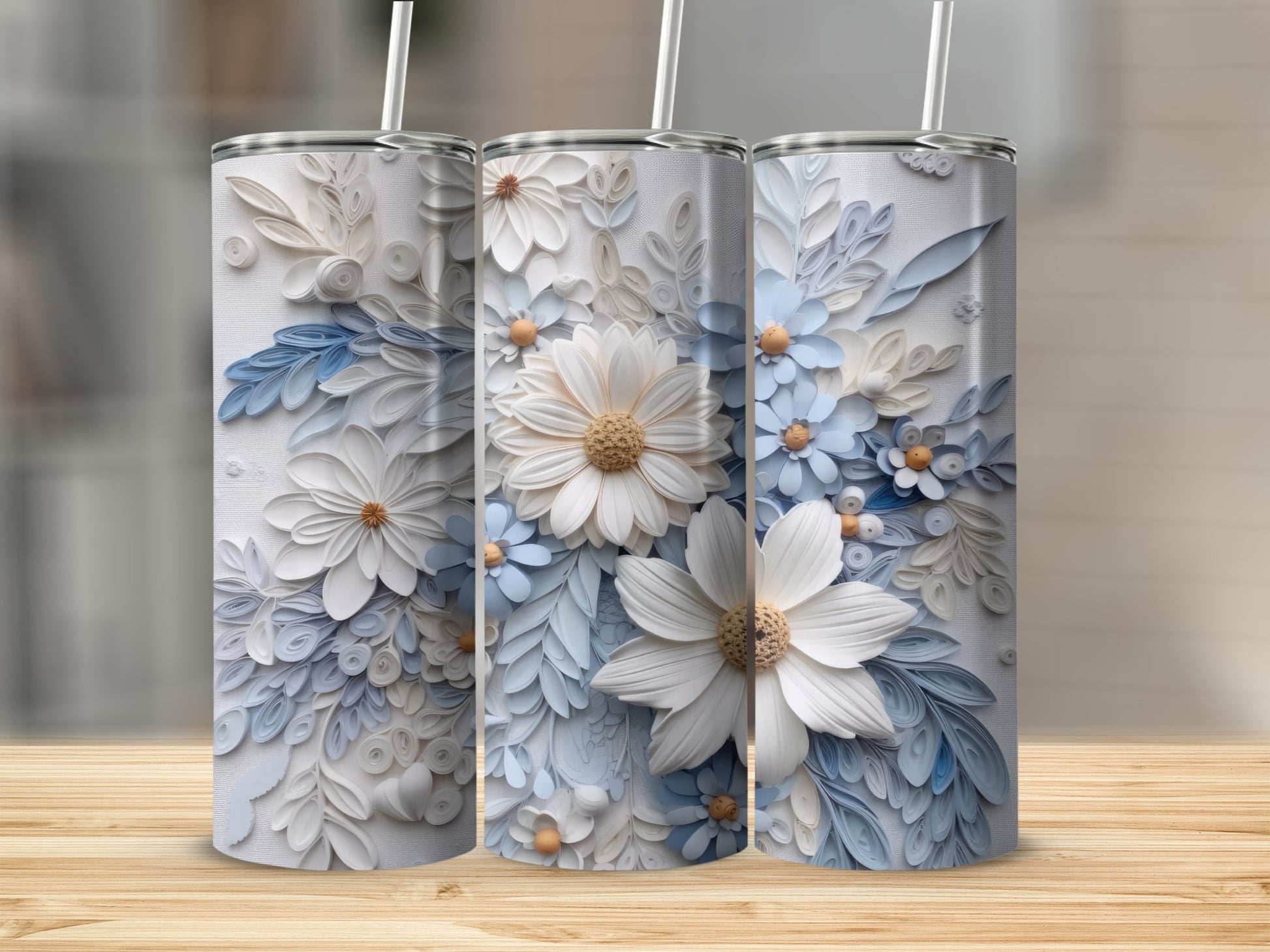 Three white tumblers adorned with intricate white and blue floral paper art designs.