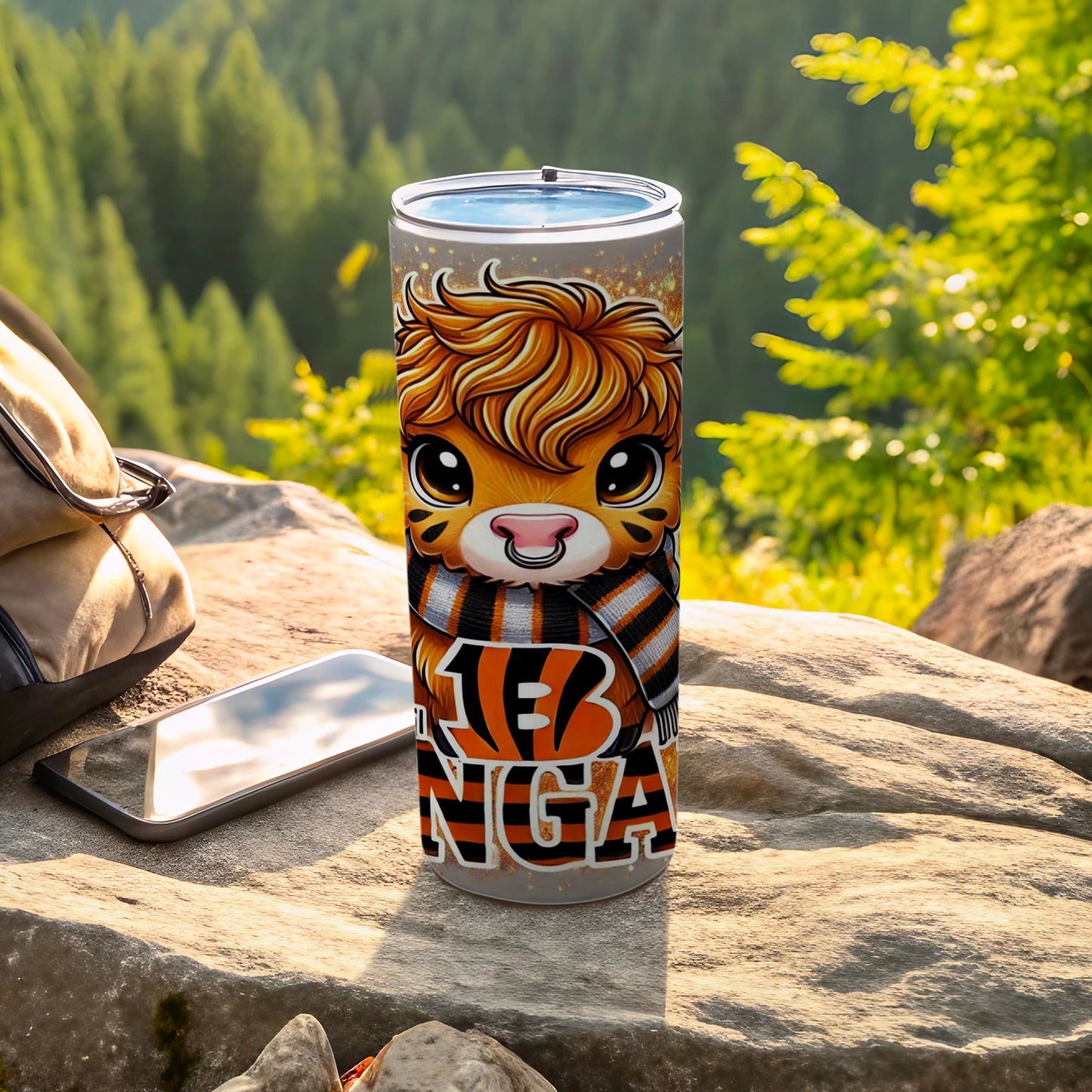 Cincinnati Bengals themed tumbler with cartoon tiger, resting on rocks outdoors.