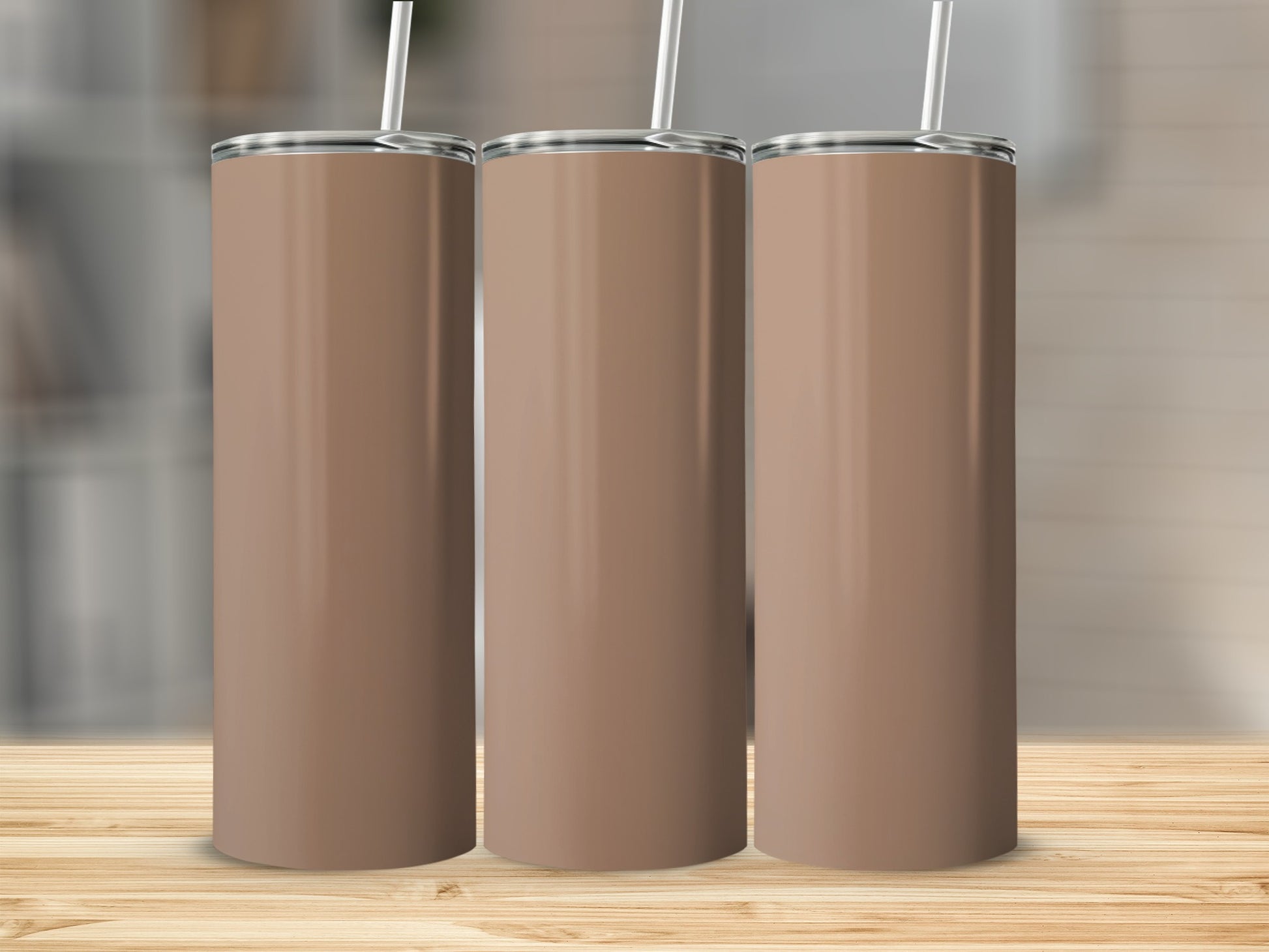 Three plain brown tumblers with white straws on a wooden surface.