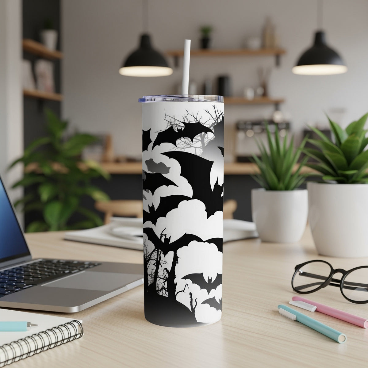 White tumbler with black bats, clouds, and spooky trees Halloween design.