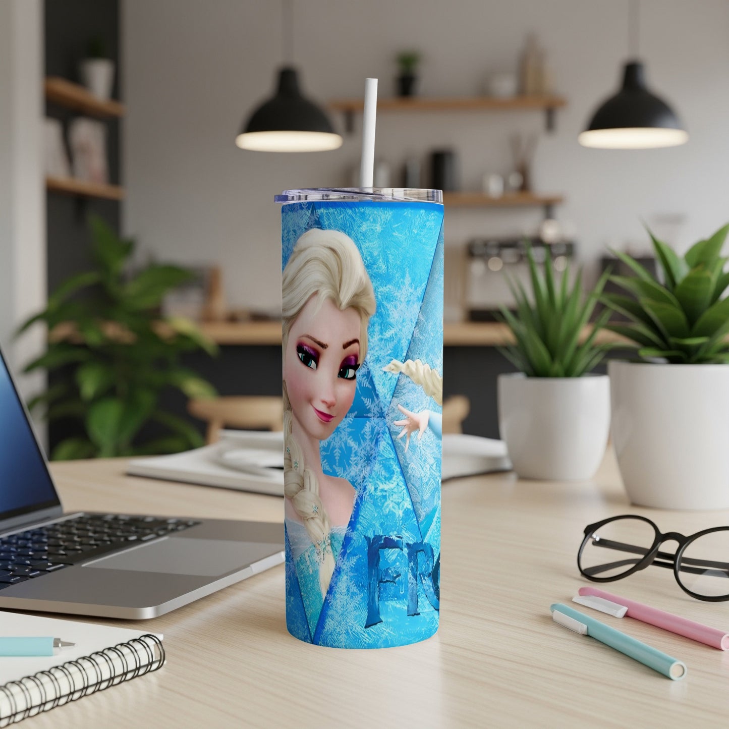 Elsa from Frozen on a blue tumbler with snowflake pattern.