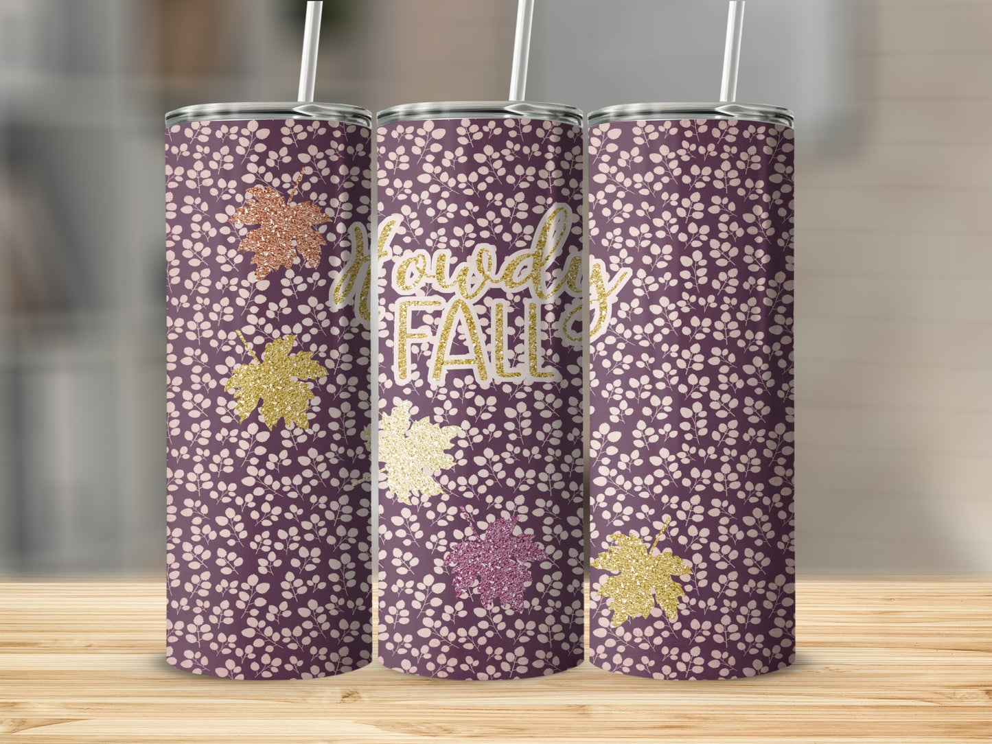 Purple tumbler with white floral pattern and "Howdy Fall" text and glitter leaves.