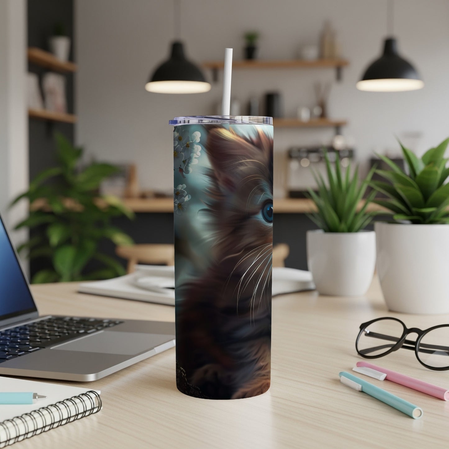 Brown cat illustration on a white tumbler with a straw, on a desk.
