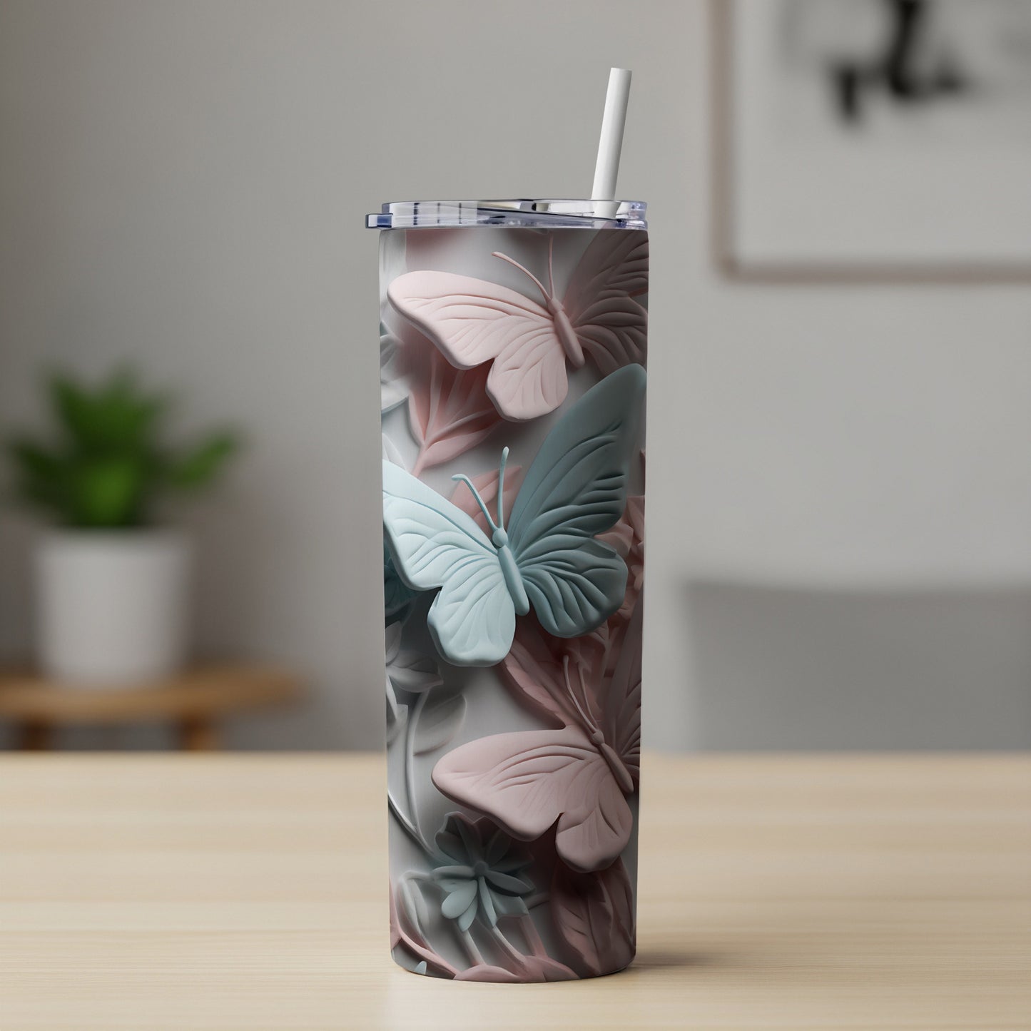 Tall tumbler with raised pastel butterflies and a straw.