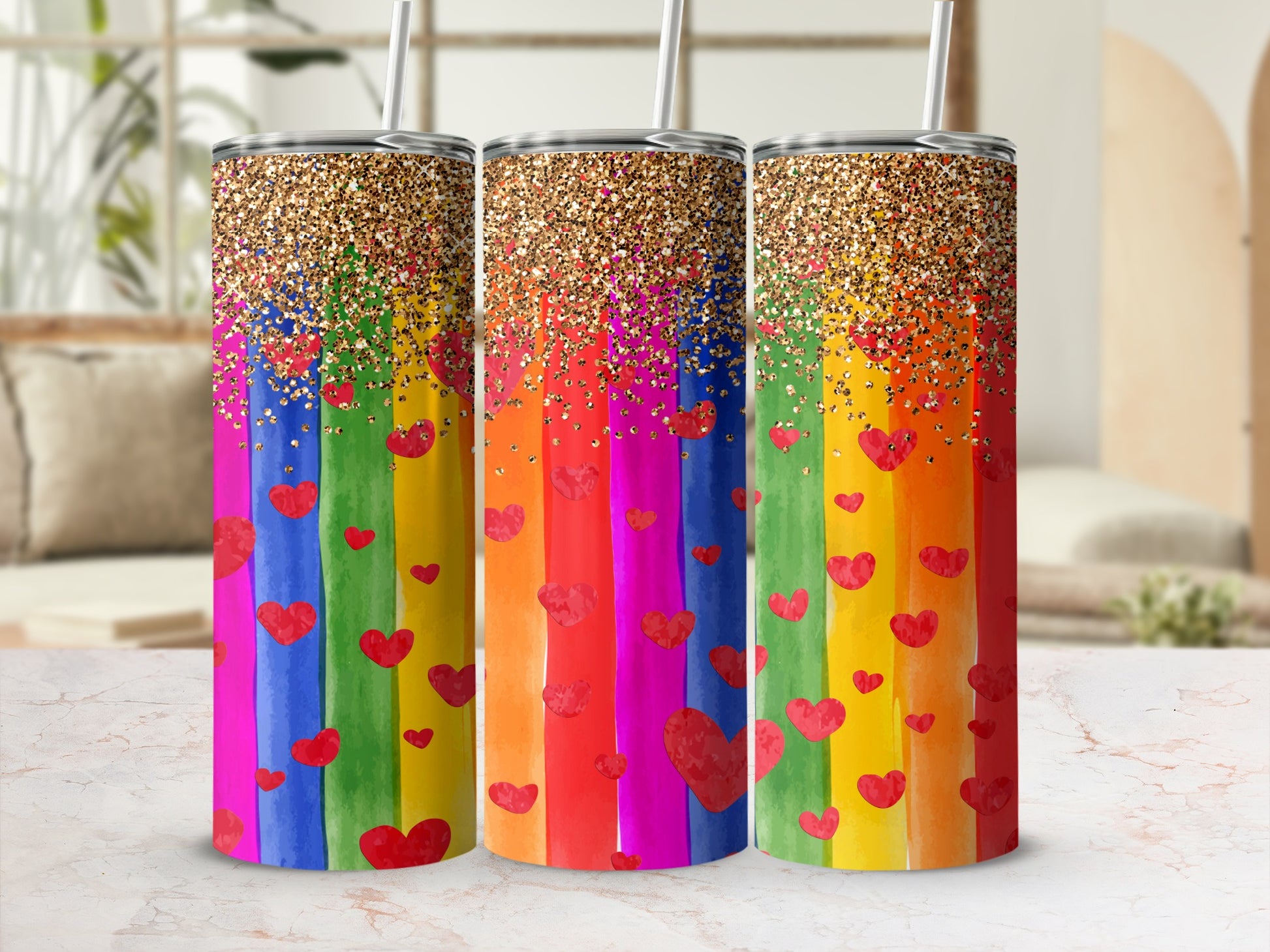 Three rainbow-striped tumblers with red hearts and gold glitter tops.