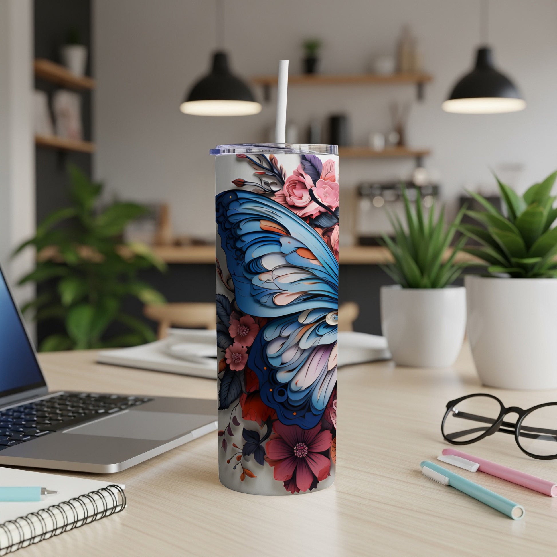 Tumbler with blue butterfly and pink floral design, featuring a straw.