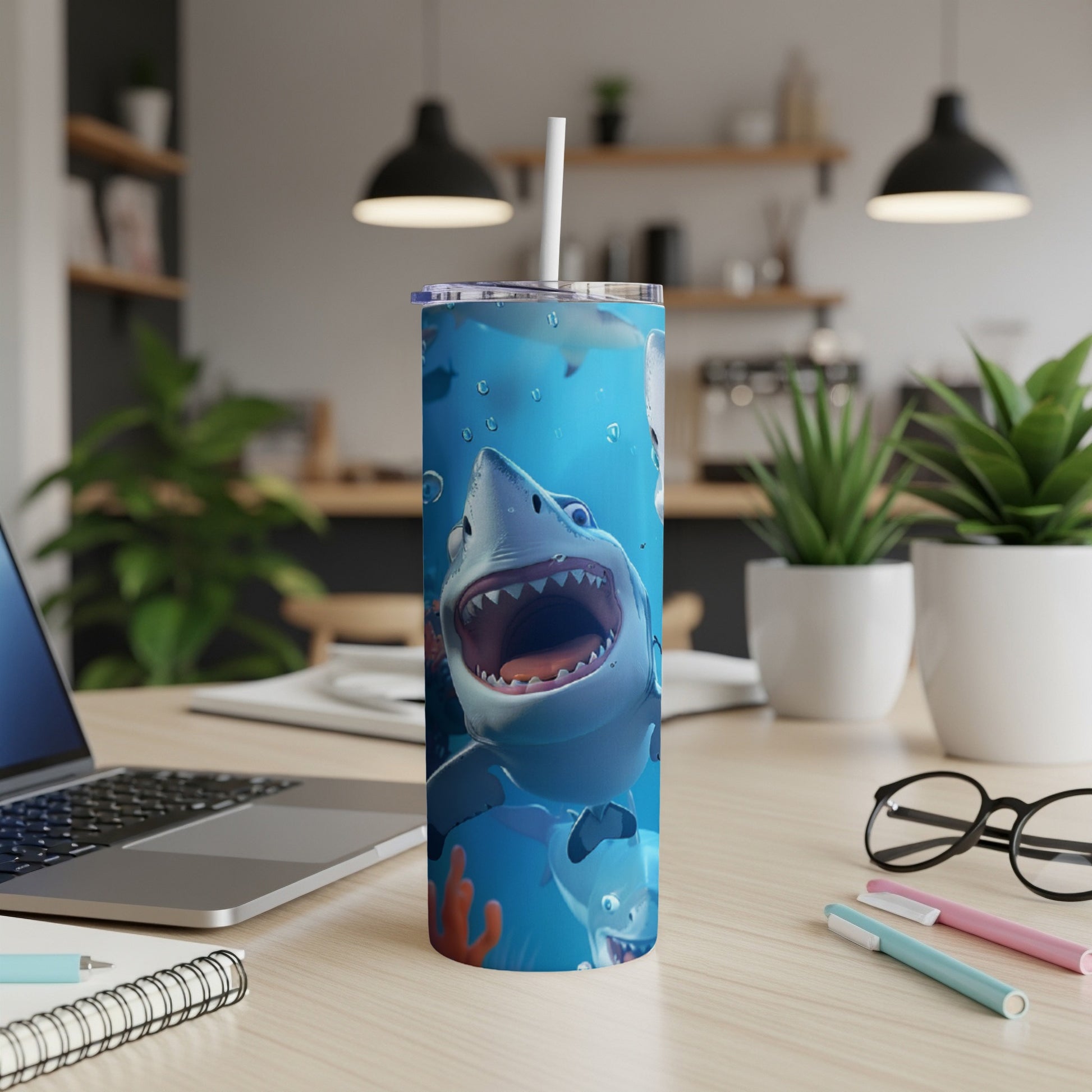 Tumbler featuring cartoon sharks and coral, with a straw in the lid.