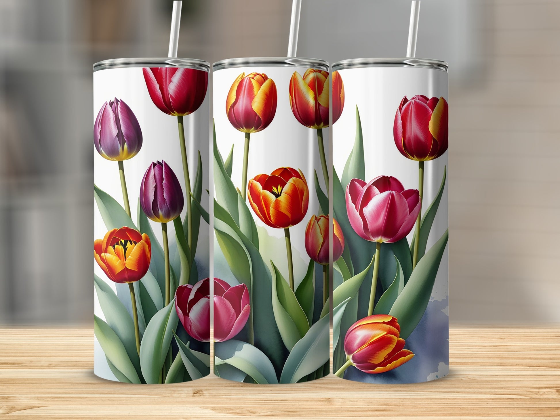 Three tumblers adorned with watercolor tulips in shades of pink, red, and yellow.