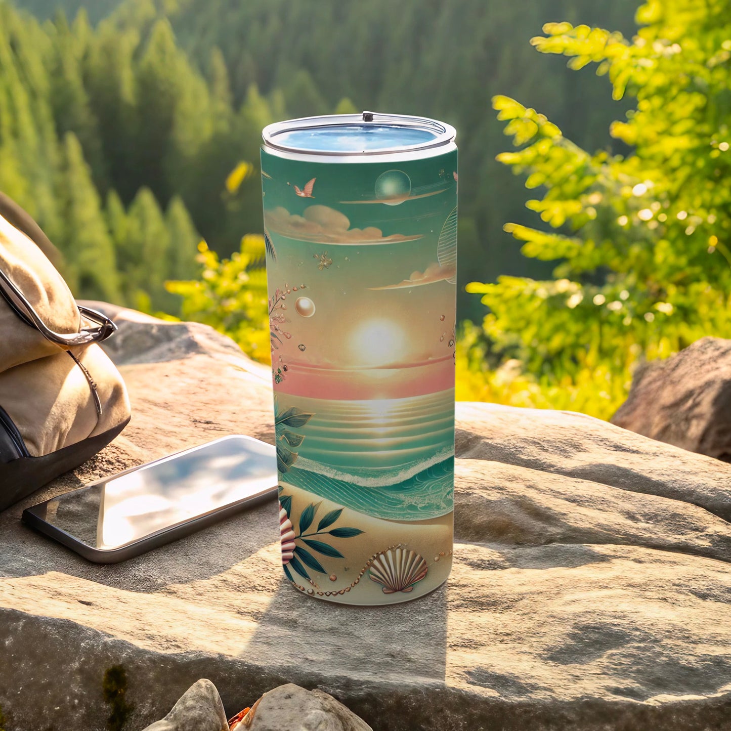 Beach sunset scene on a tall, slim tumbler next to a phone and bag.