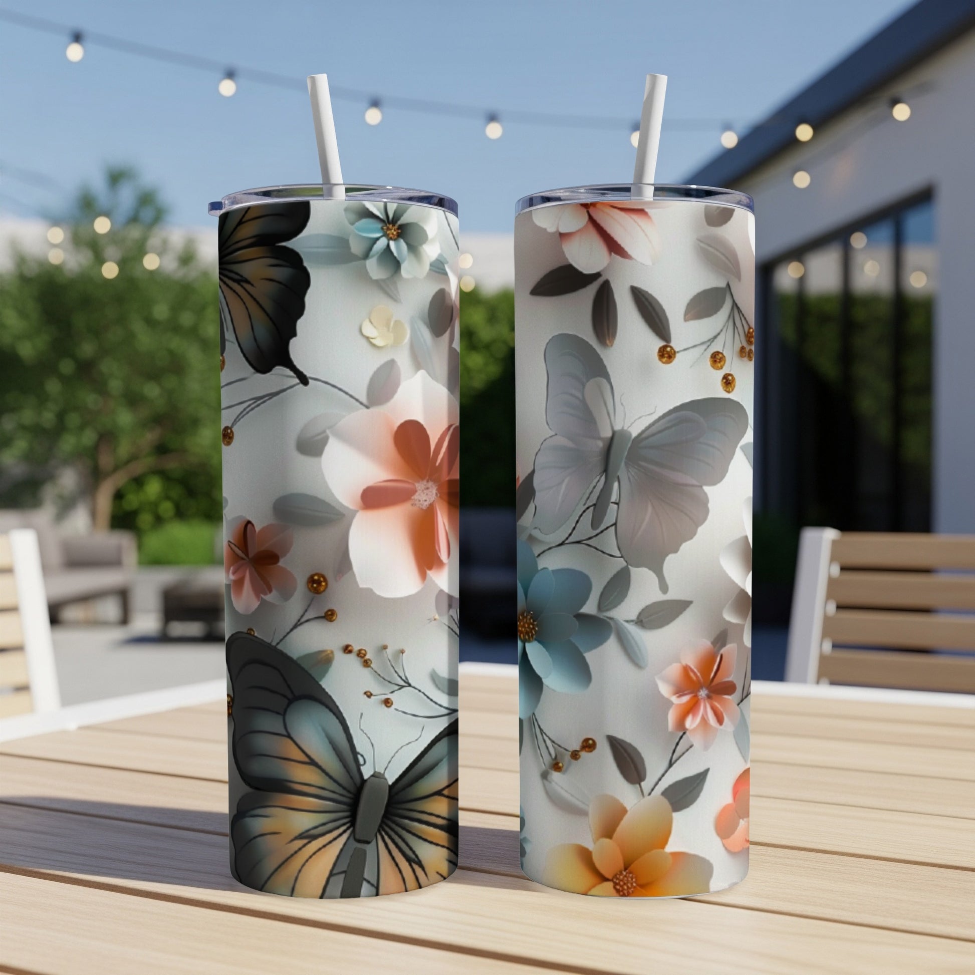 Two tumblers with butterflies and floral designs on a table.